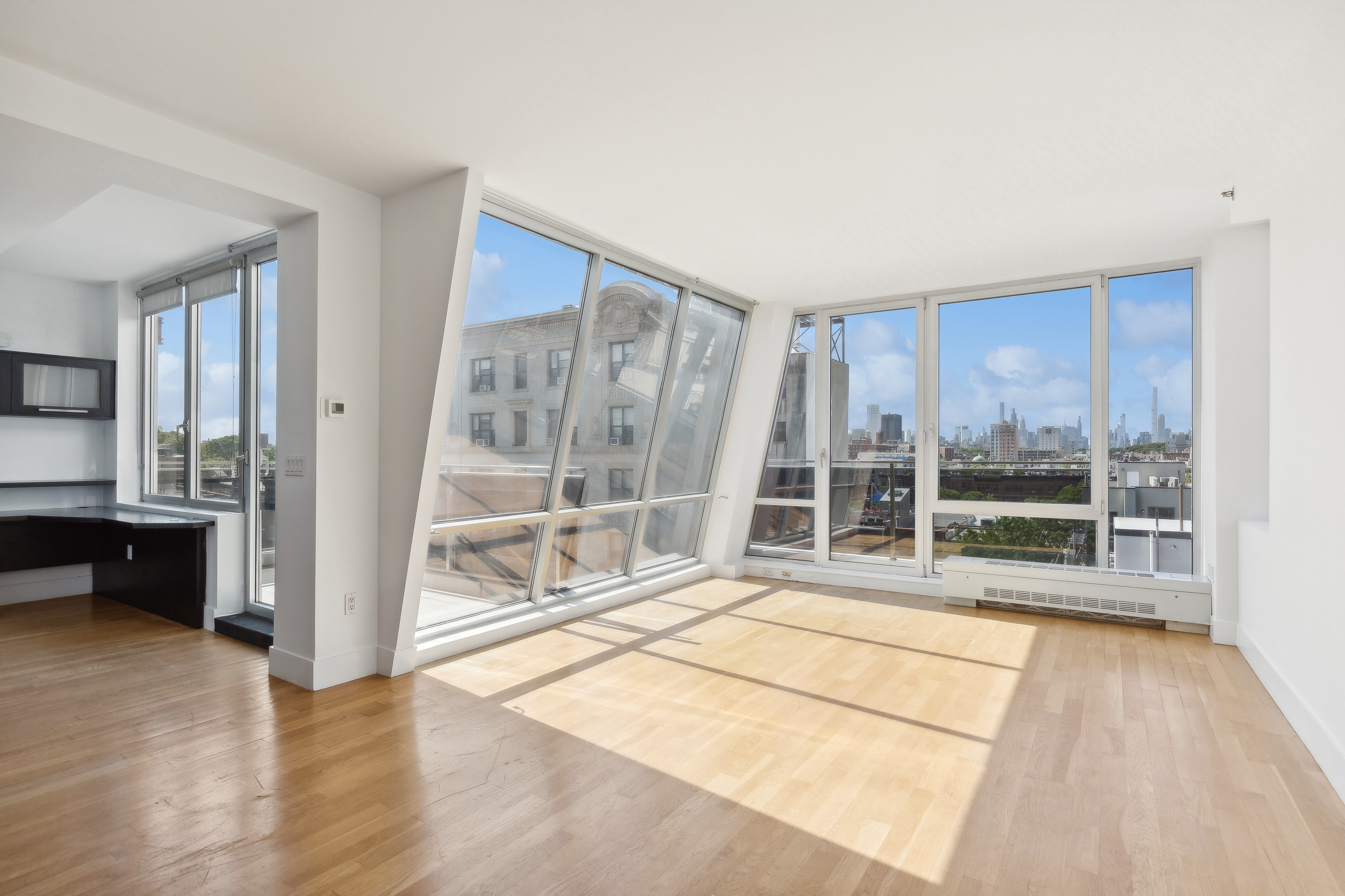 a view of empty room with wooden floor and floor to ceiling window