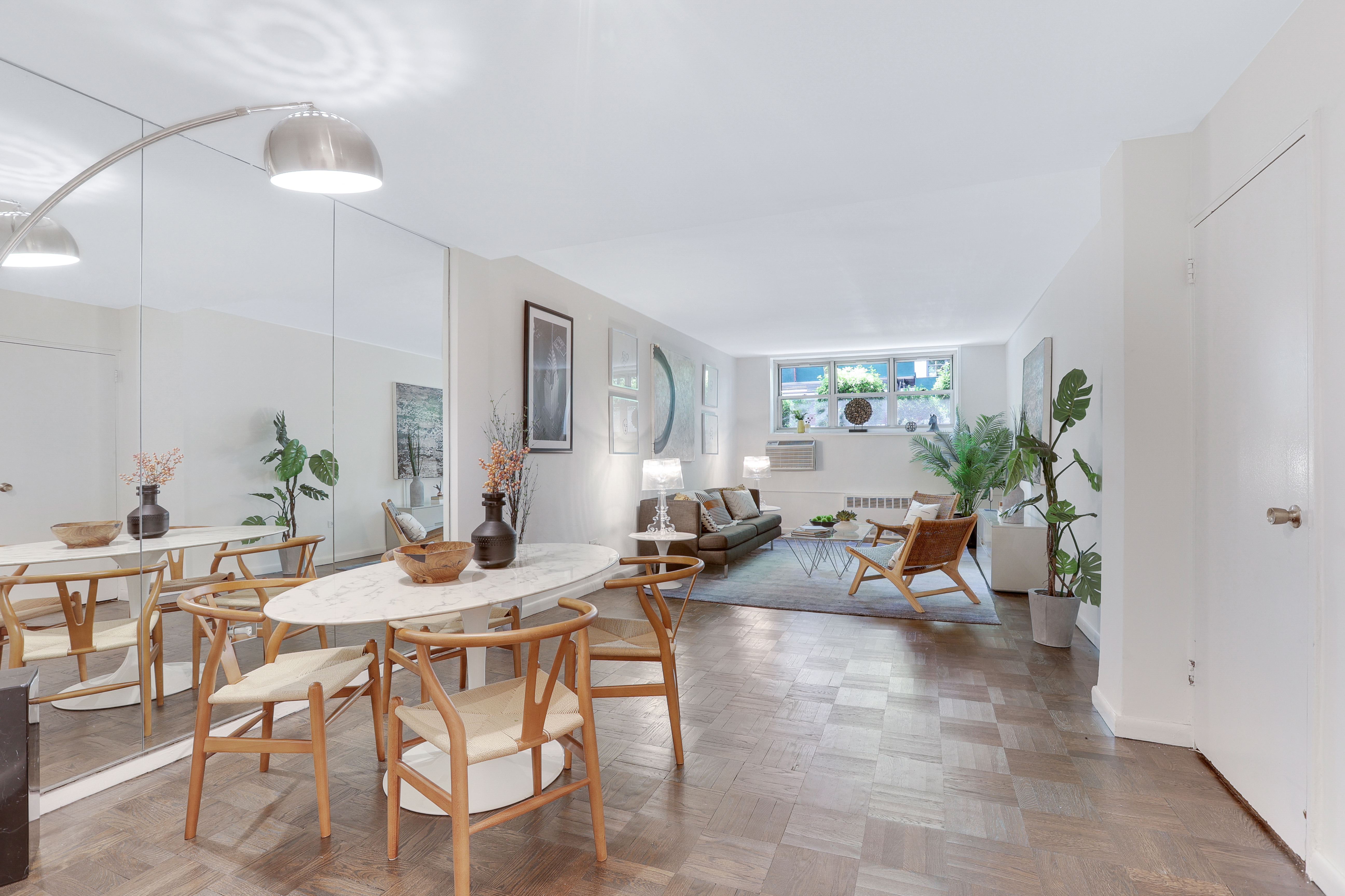 a living room with furniture a potted plant and a chandelier