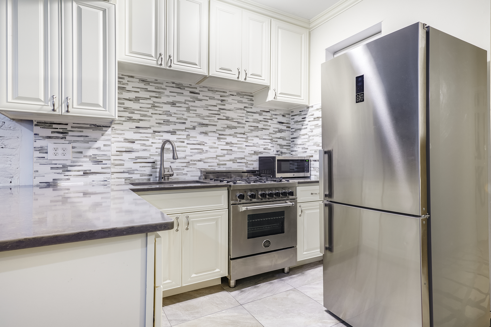 a kitchen with stainless steel appliances granite countertop a refrigerator and a sink