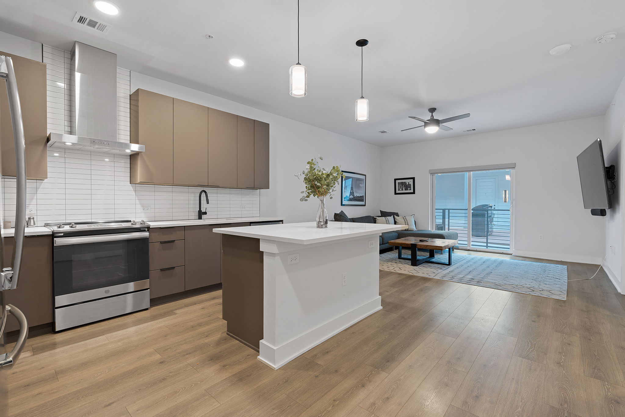 a large white kitchen with a stove and a wooden floor