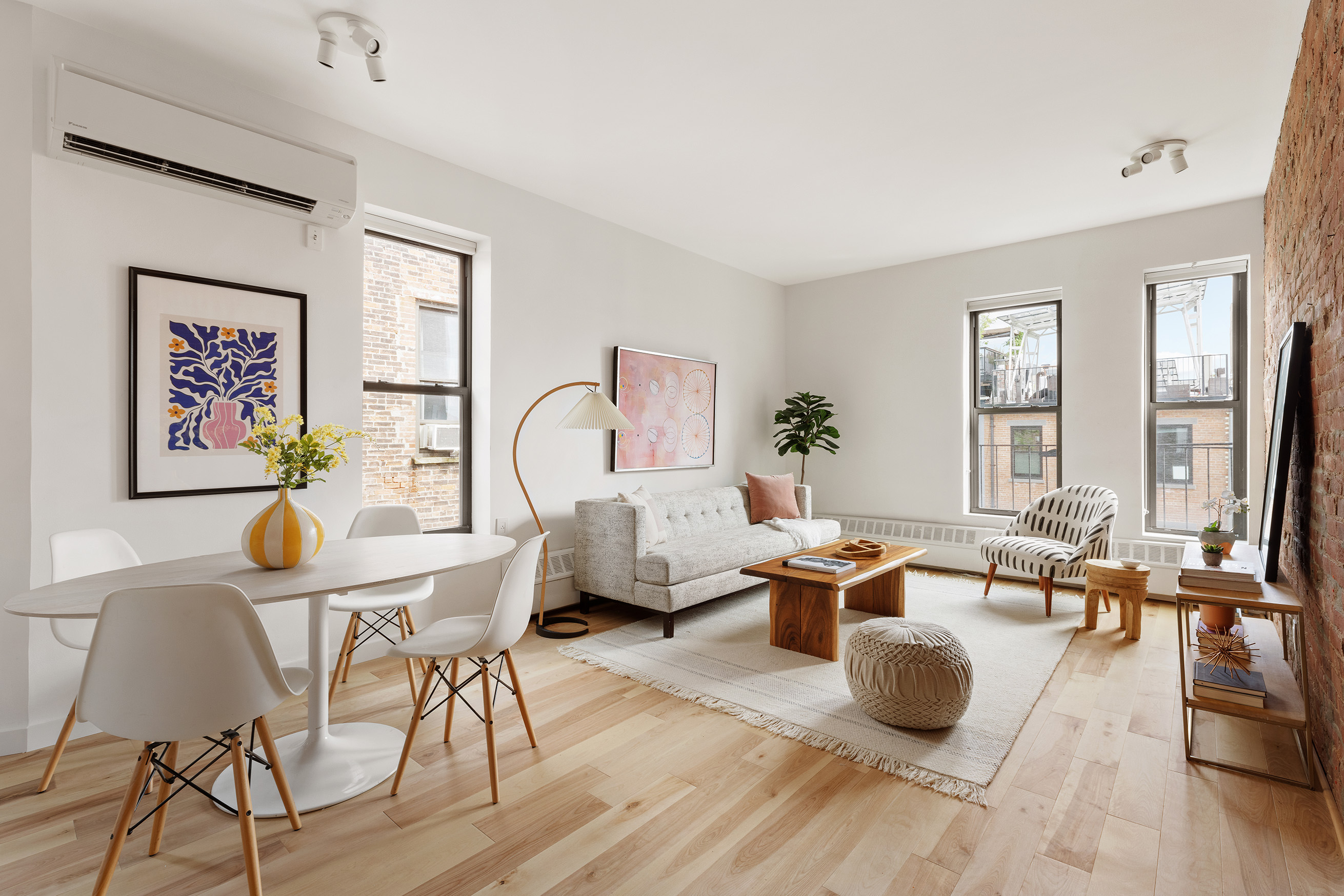 a living room with furniture large window and wooden floor