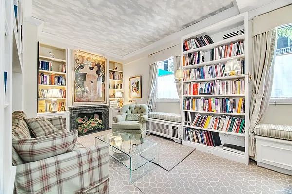 a living room with fireplace furniture and a book shelf