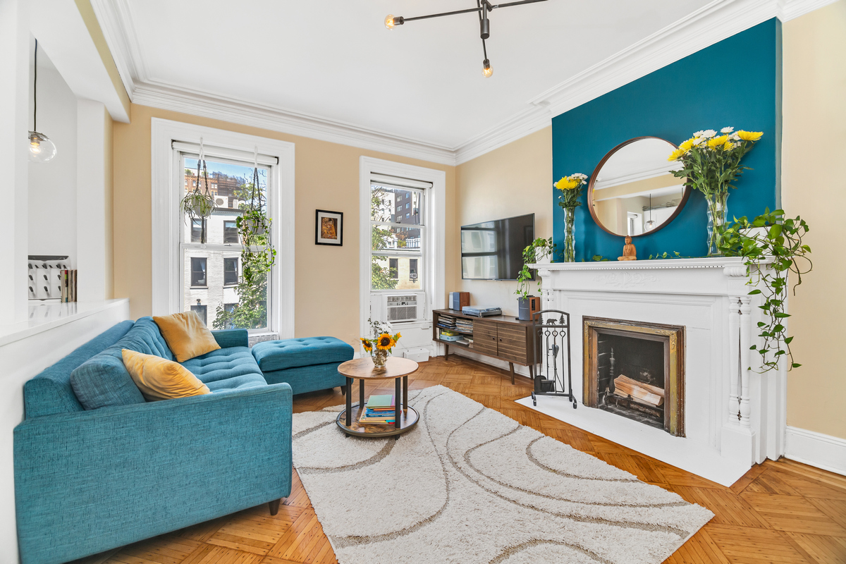 a living room with furniture a fireplace and a large window