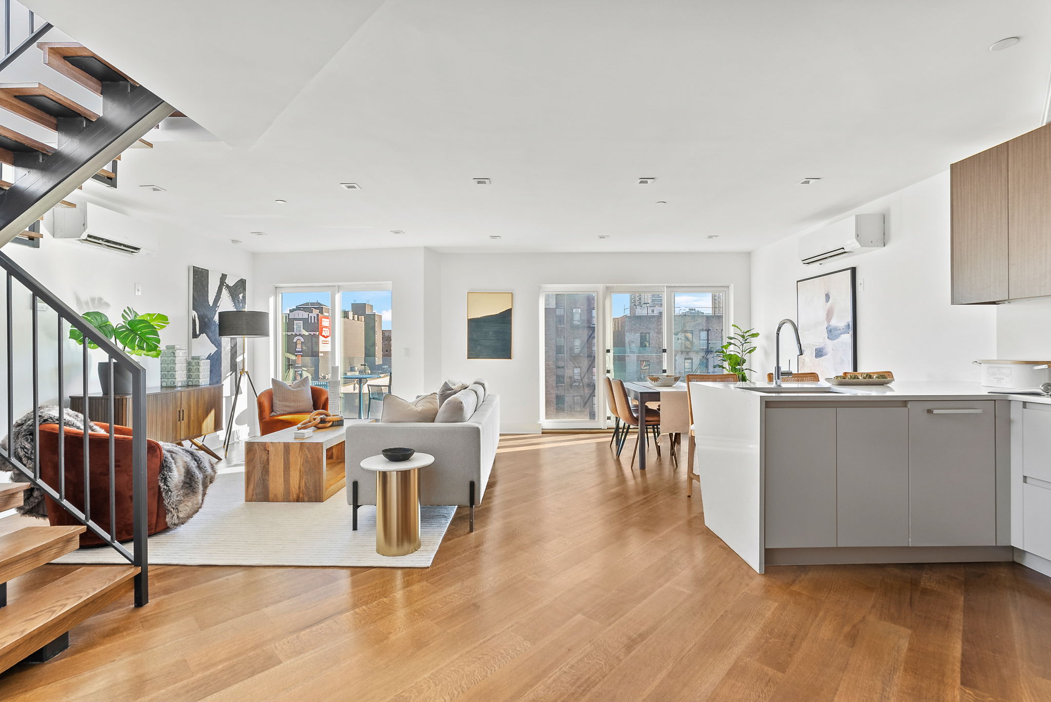 a living room with furniture a wooden floor and next to a window