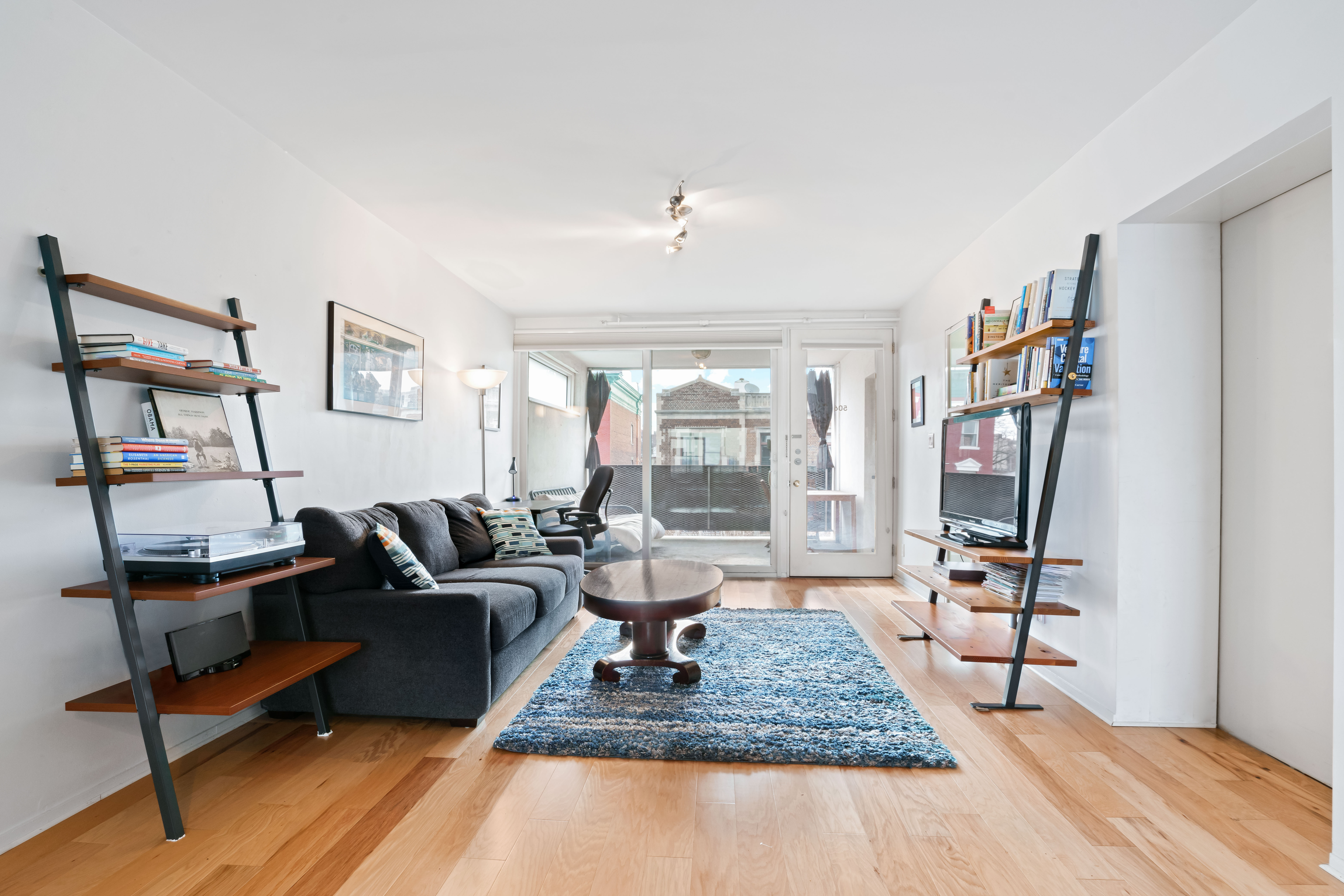 a living room with furniture and a flat screen tv with wooden floor