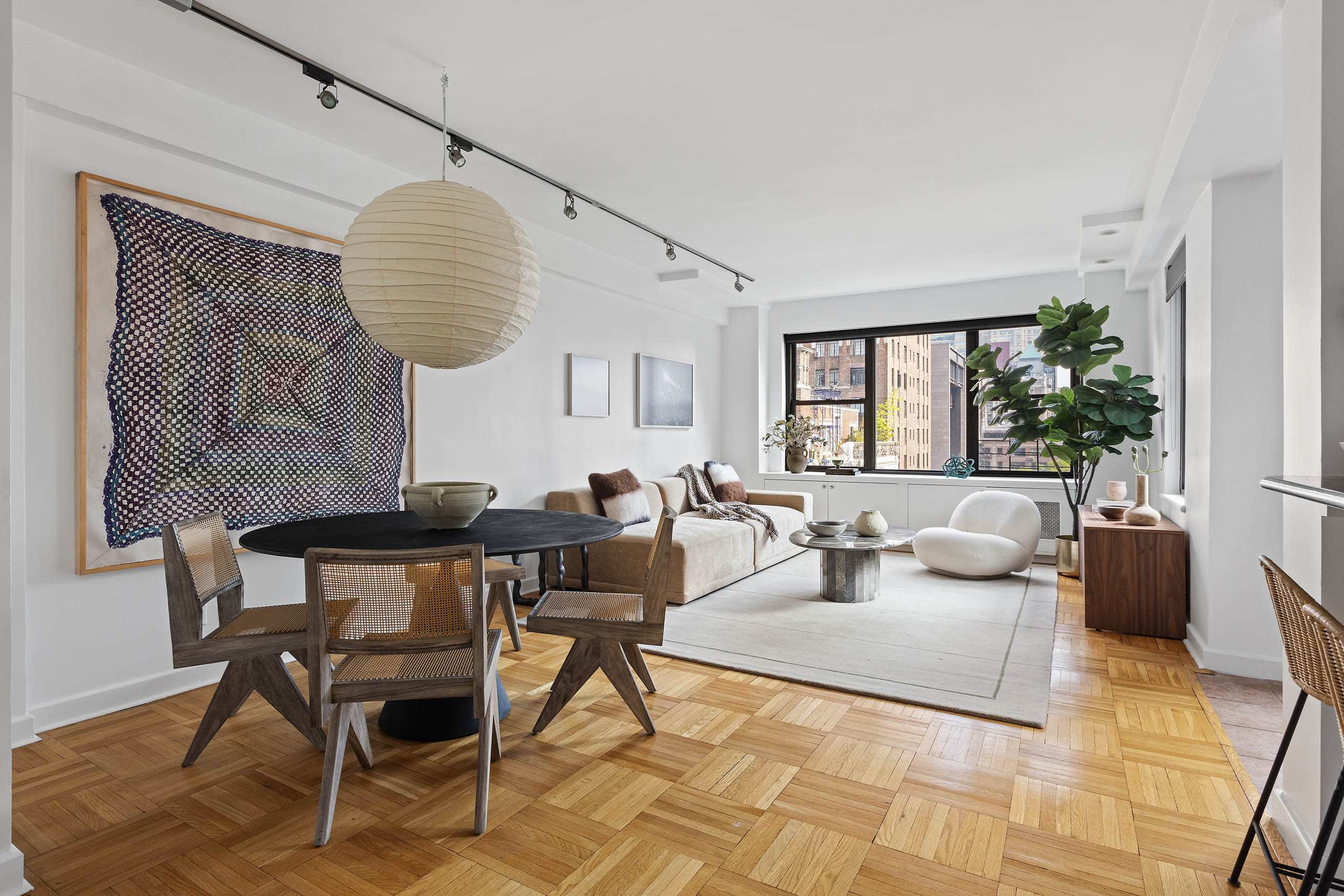 a living room with furniture a table and a large window