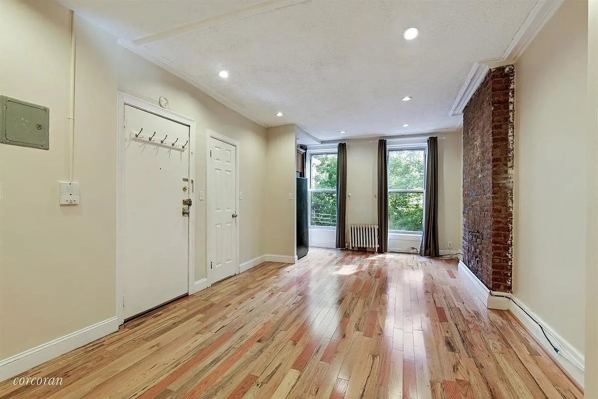 a view of hallway with a large window and wooden floor