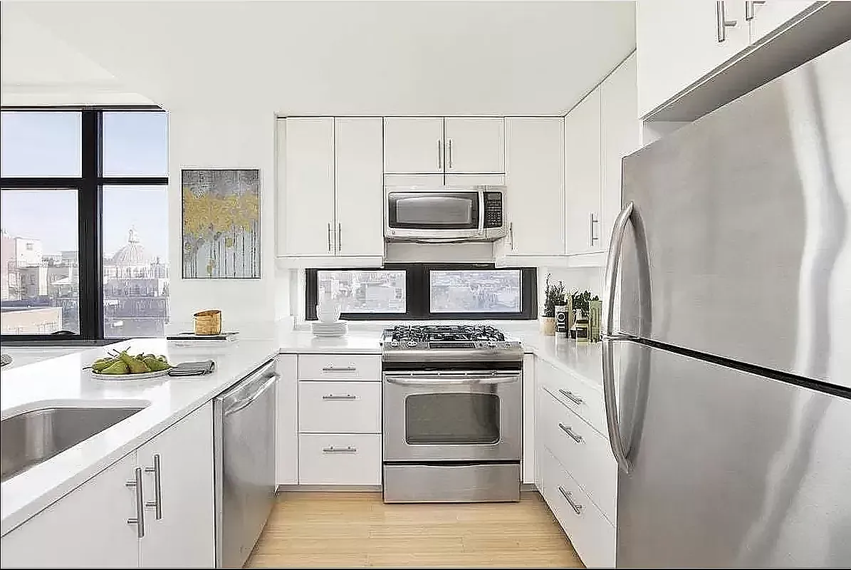 a kitchen with white cabinets and stainless steel appliances