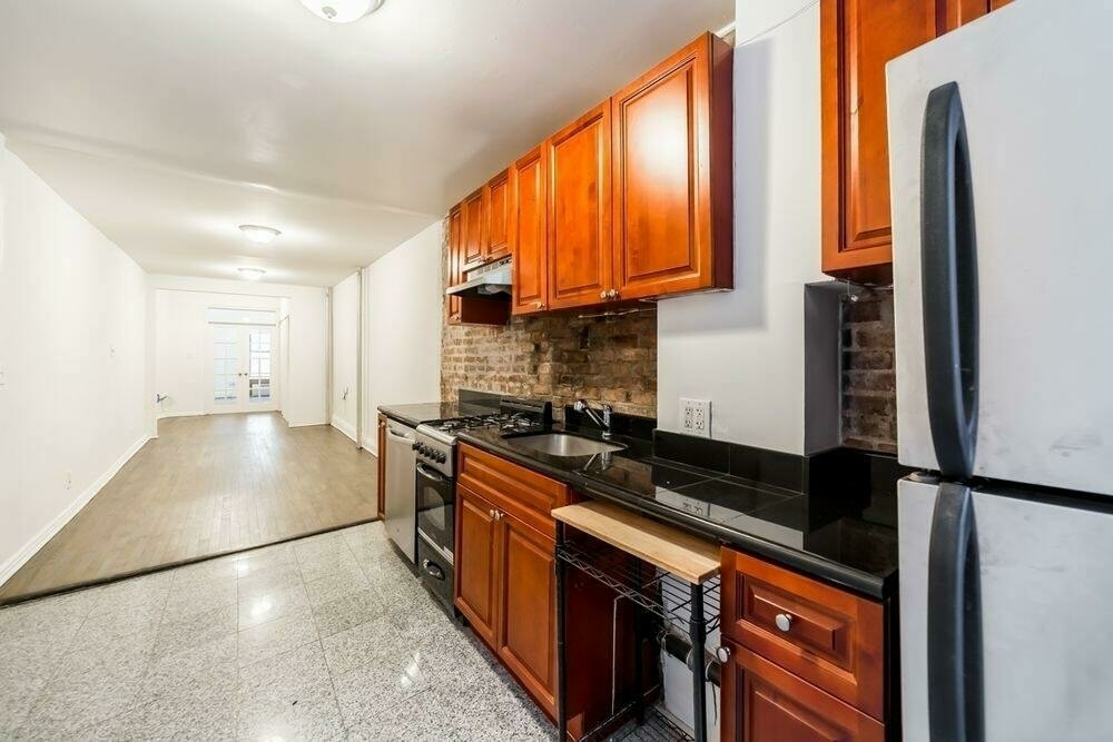 a kitchen with stainless steel appliances granite countertop a stove a sink and a refrigerator