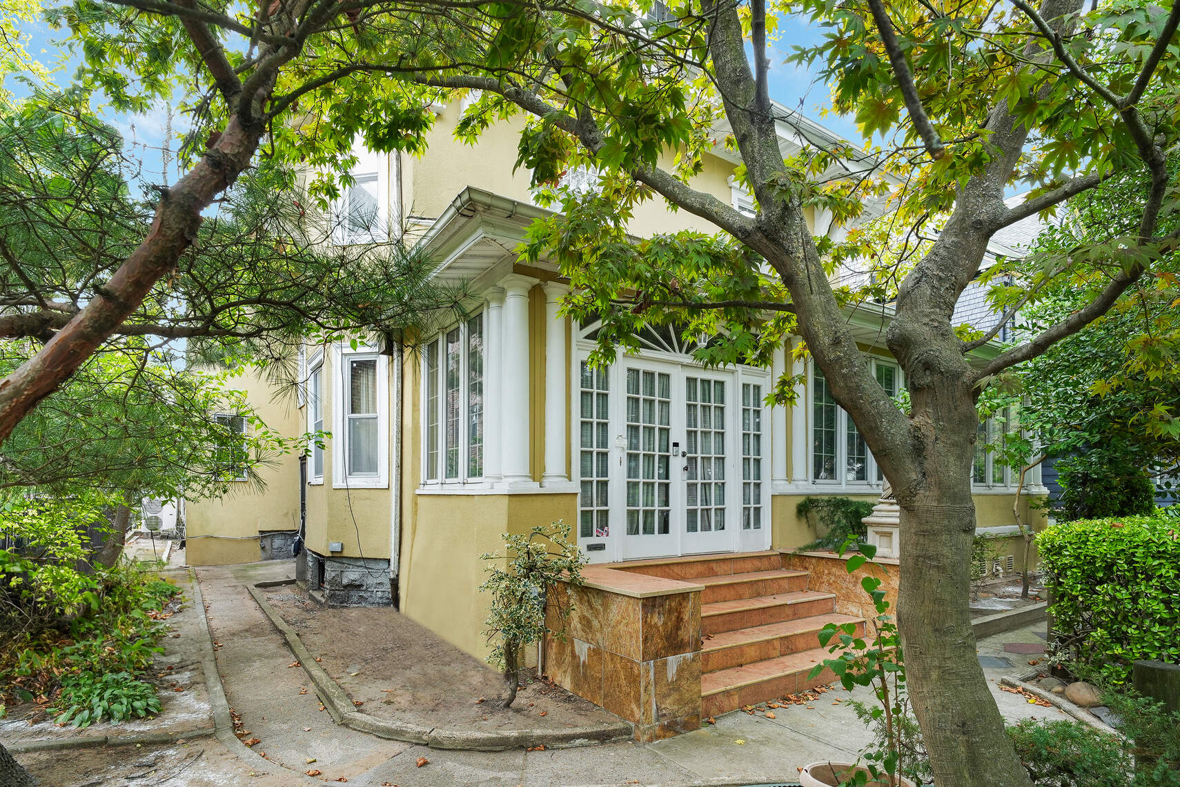 a front view of a house with a tree