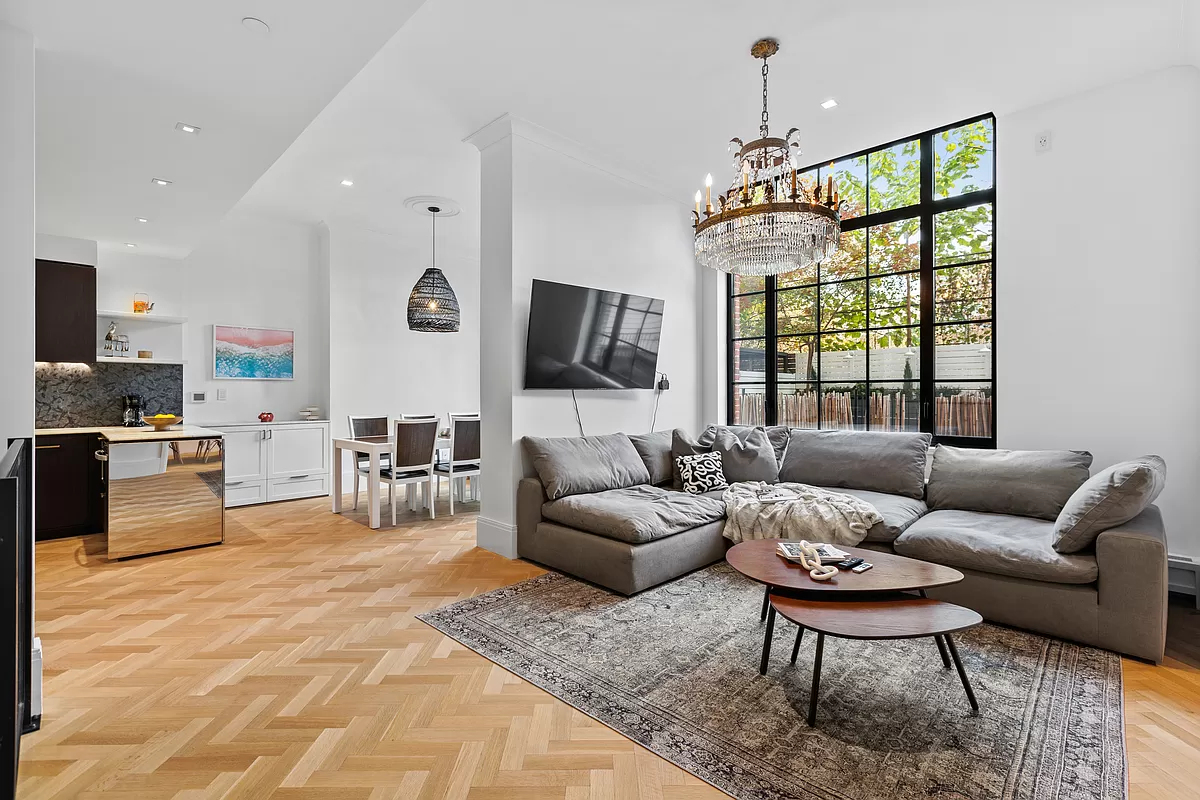 a living room with furniture a flat screen tv and a large window