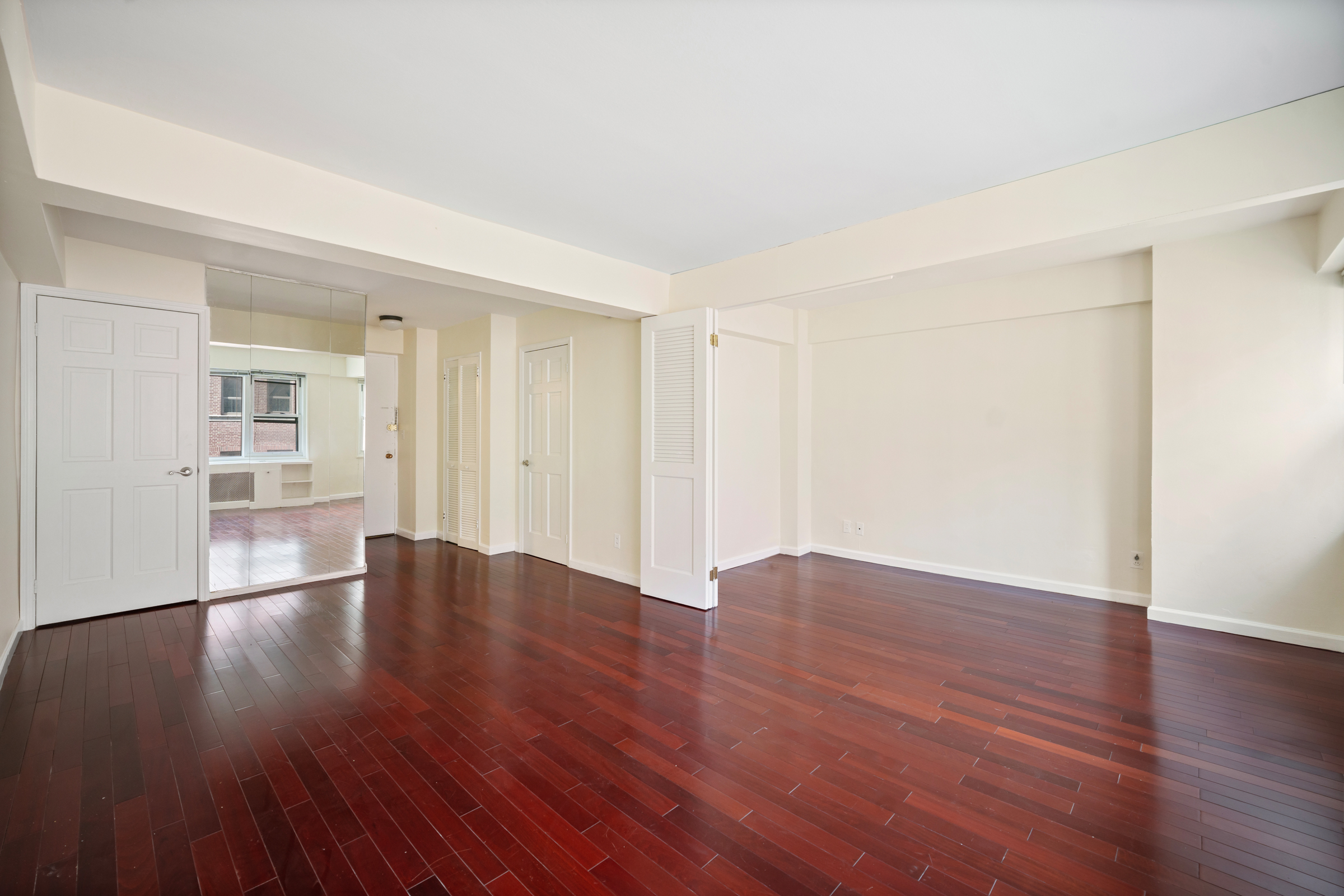 a view of an empty room with wooden floor