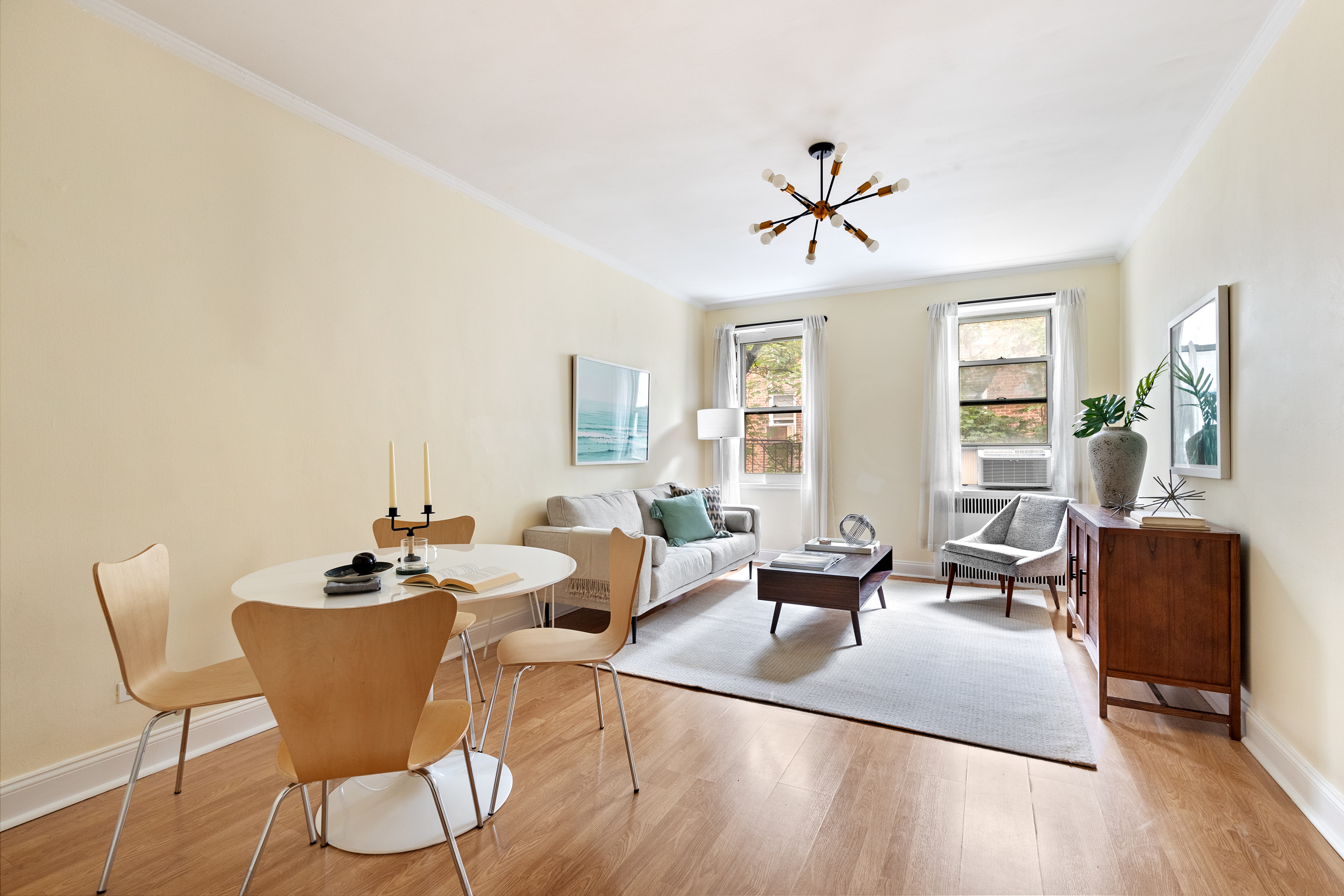 a living room with furniture a large window and wooden floor