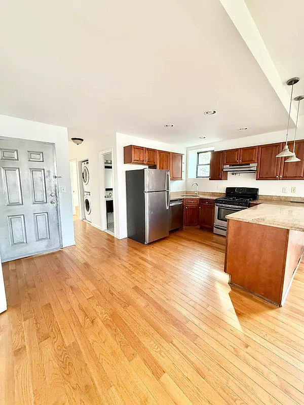 a view of a kitchen with furniture and wooden floor