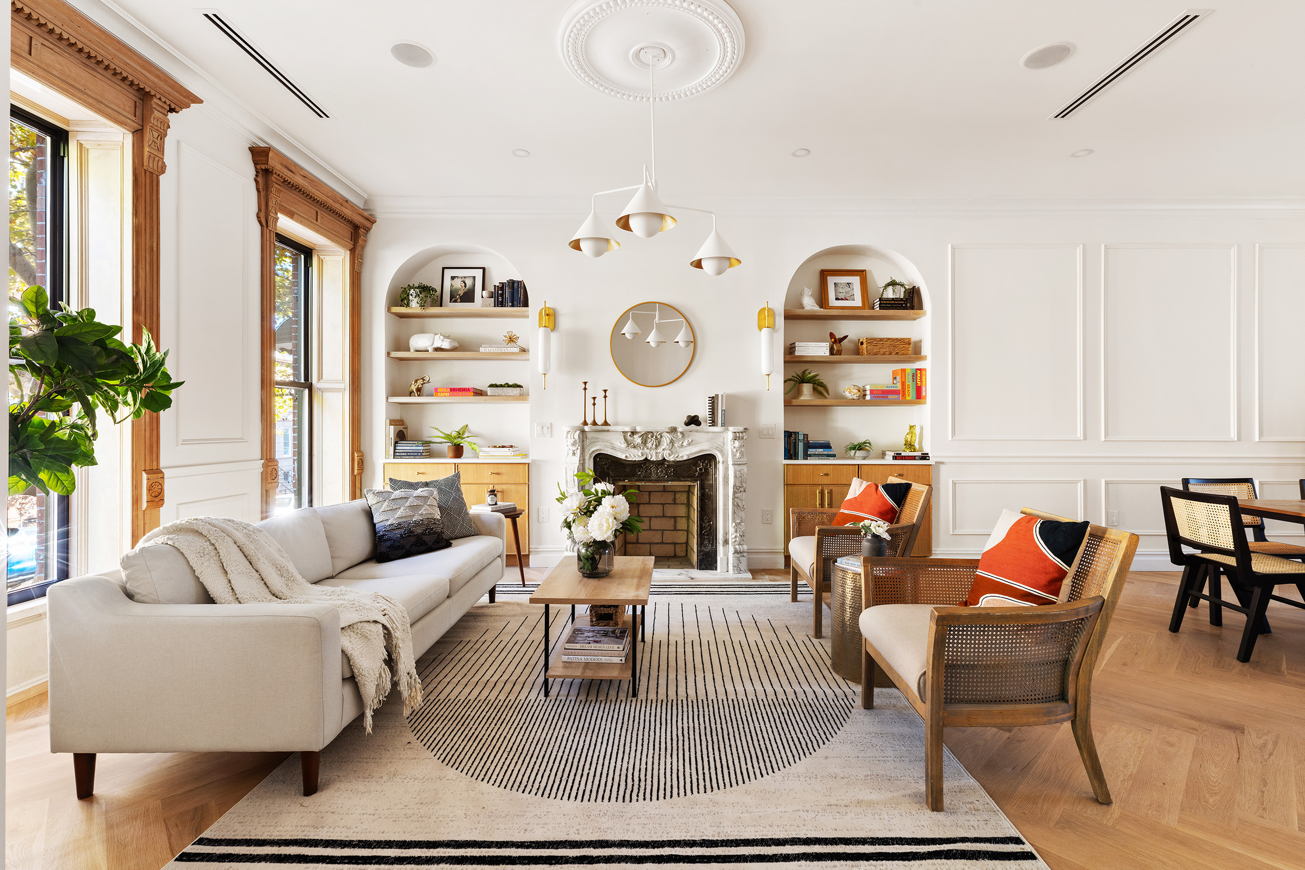 a living room with furniture a clock and a large window