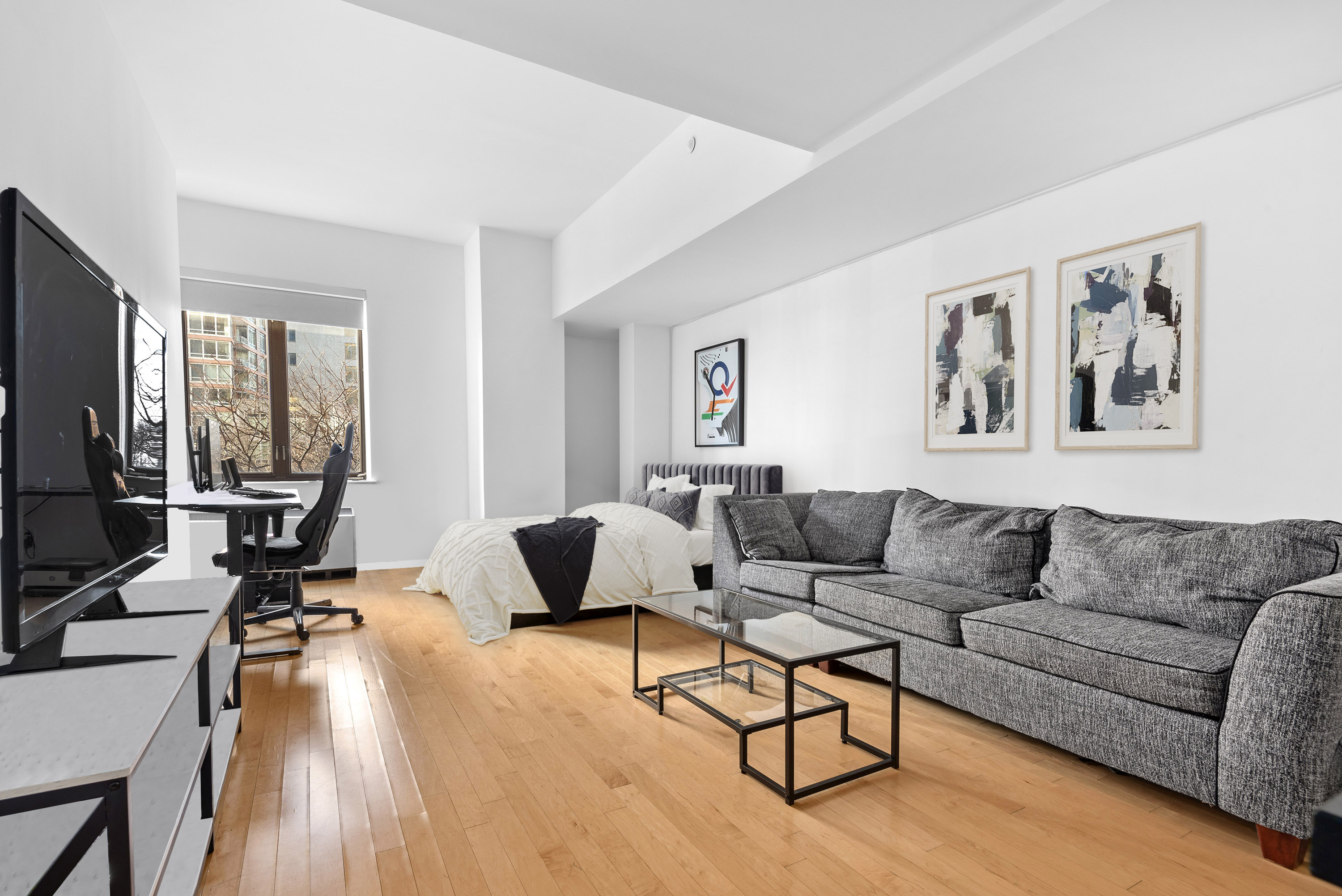 a living room with furniture and a flat screen tv with wooden floor