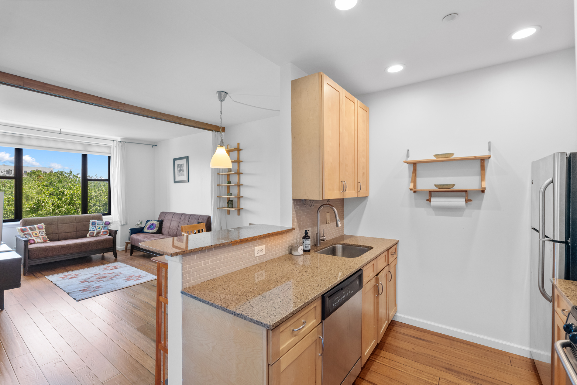 a kitchen with stainless steel appliances granite countertop a sink and a refrigerator