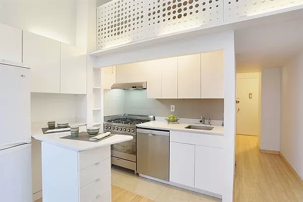 a kitchen with a sink a stove cabinets and a wooden floor