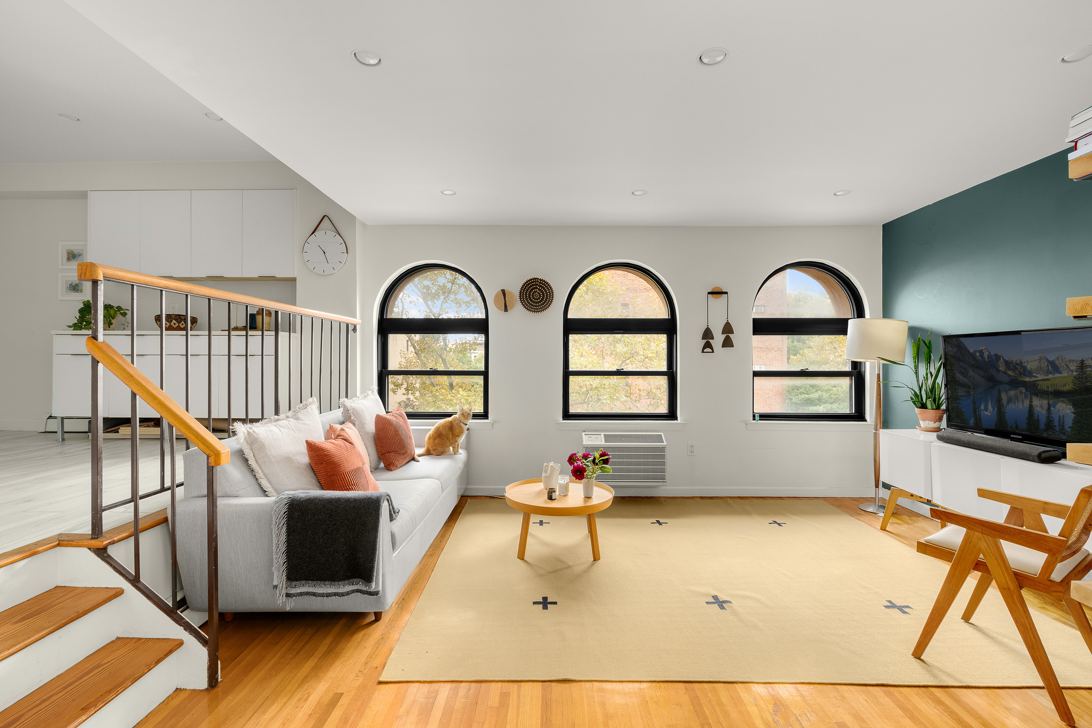 a living room with furniture a rug and a window