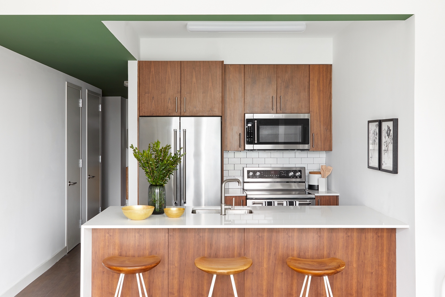 a kitchen with stainless steel appliances a microwave a stove and white cabinets