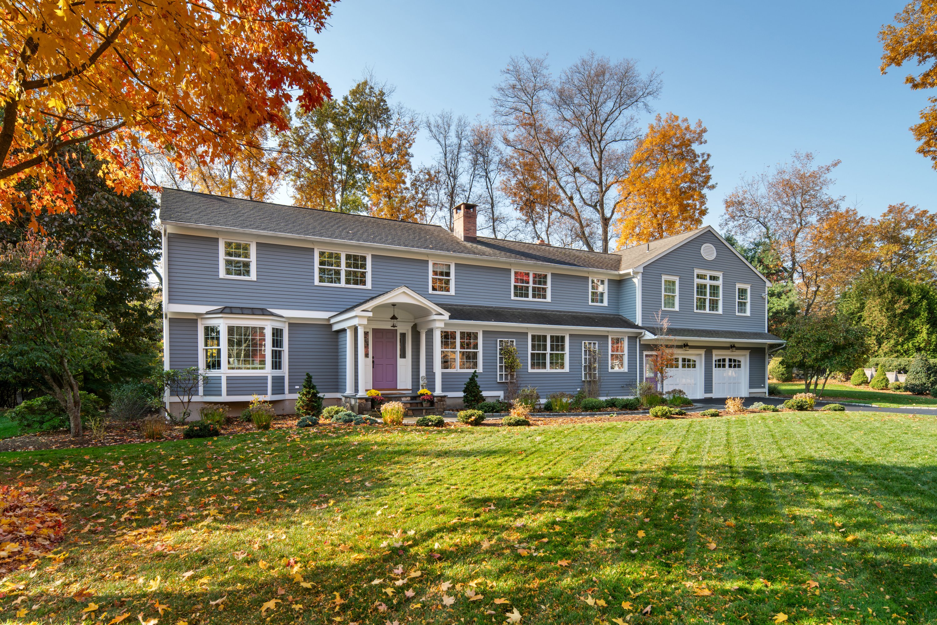 a front view of residential houses with yard and green space