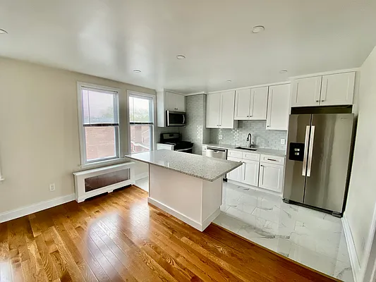 a kitchen with granite countertop a refrigerator and wooden cabinets