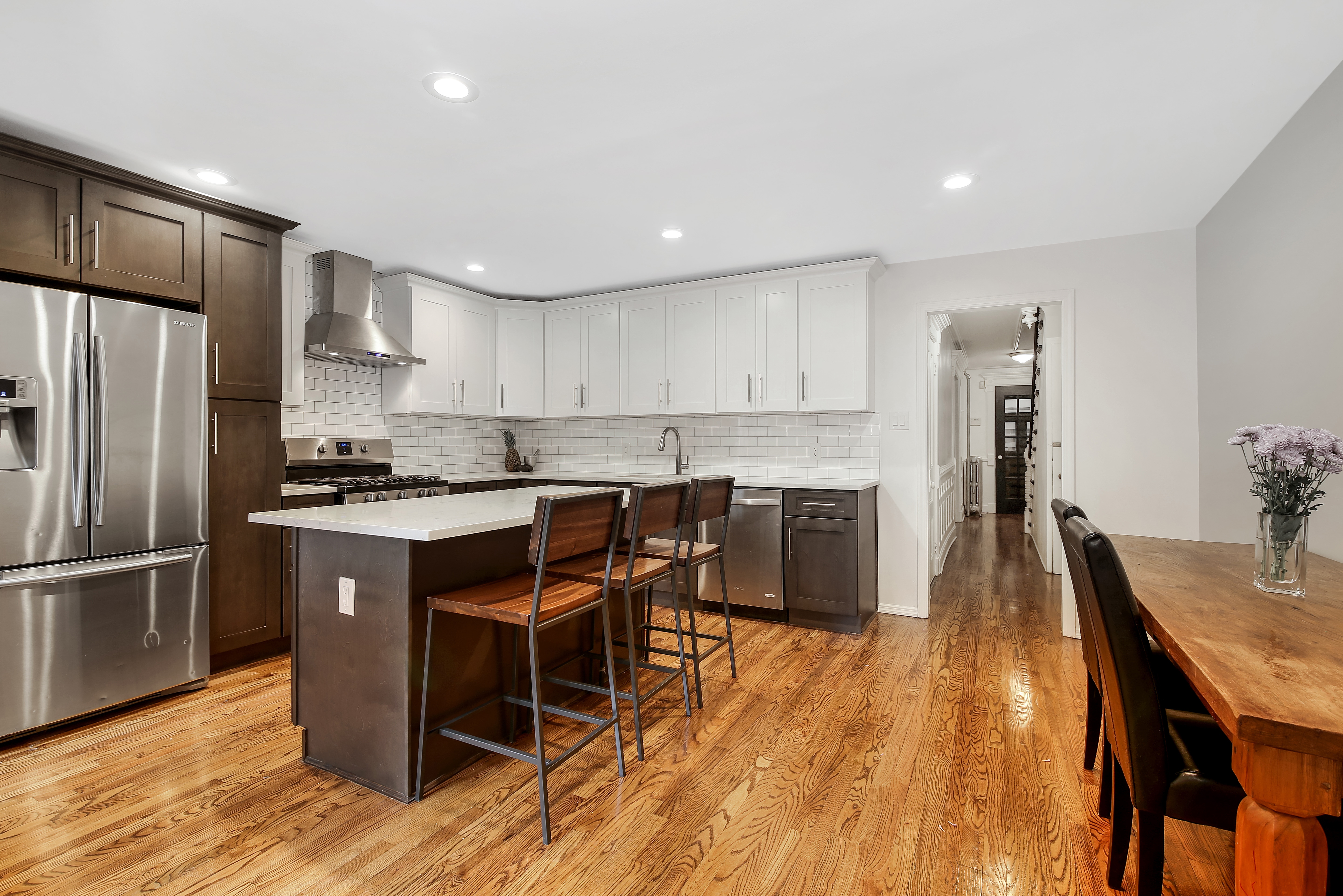 a kitchen with stainless steel appliances granite countertop a table chairs sink refrigerator and cabinets