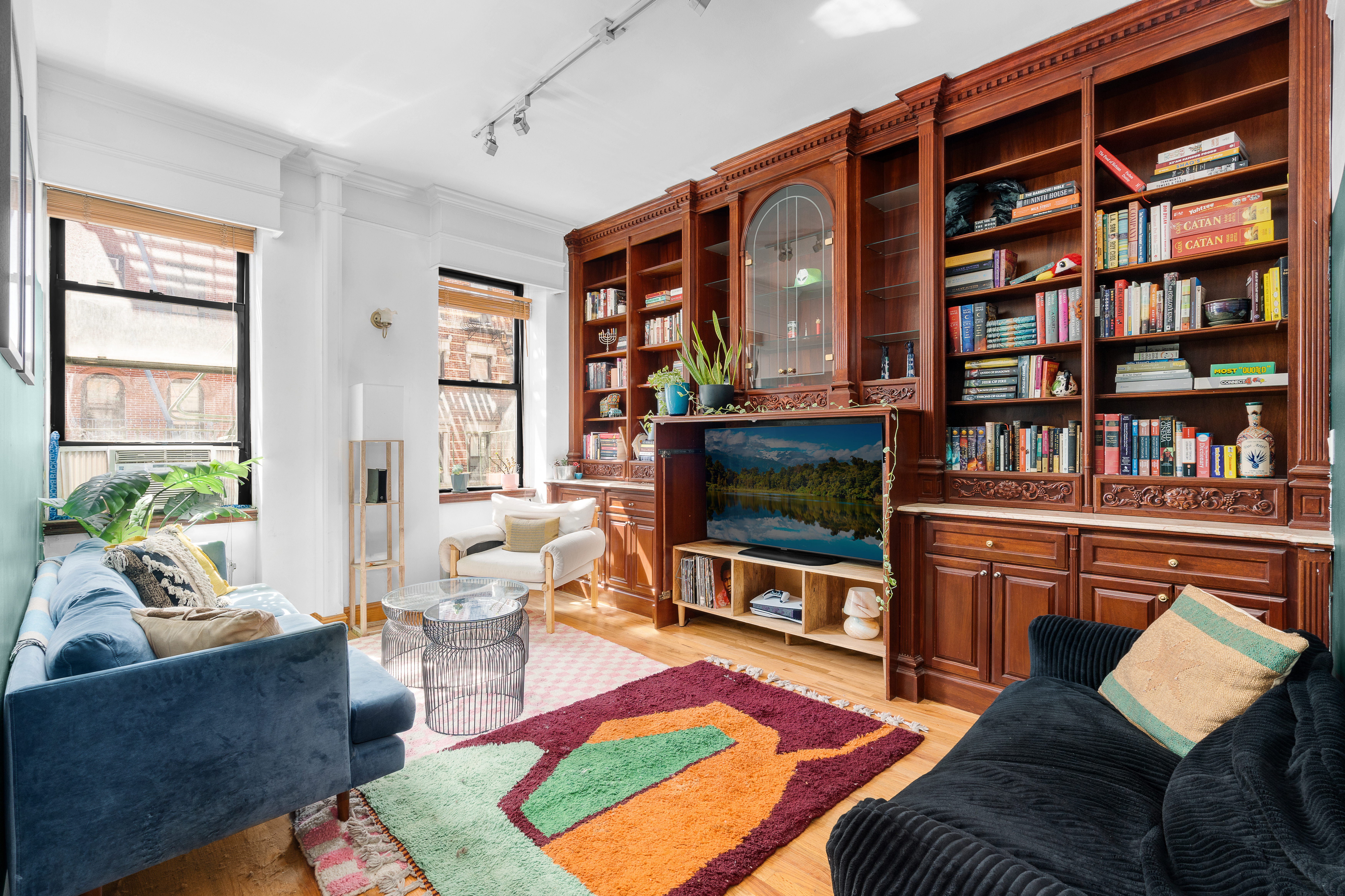 a living room with furniture a rug and a flat screen tv