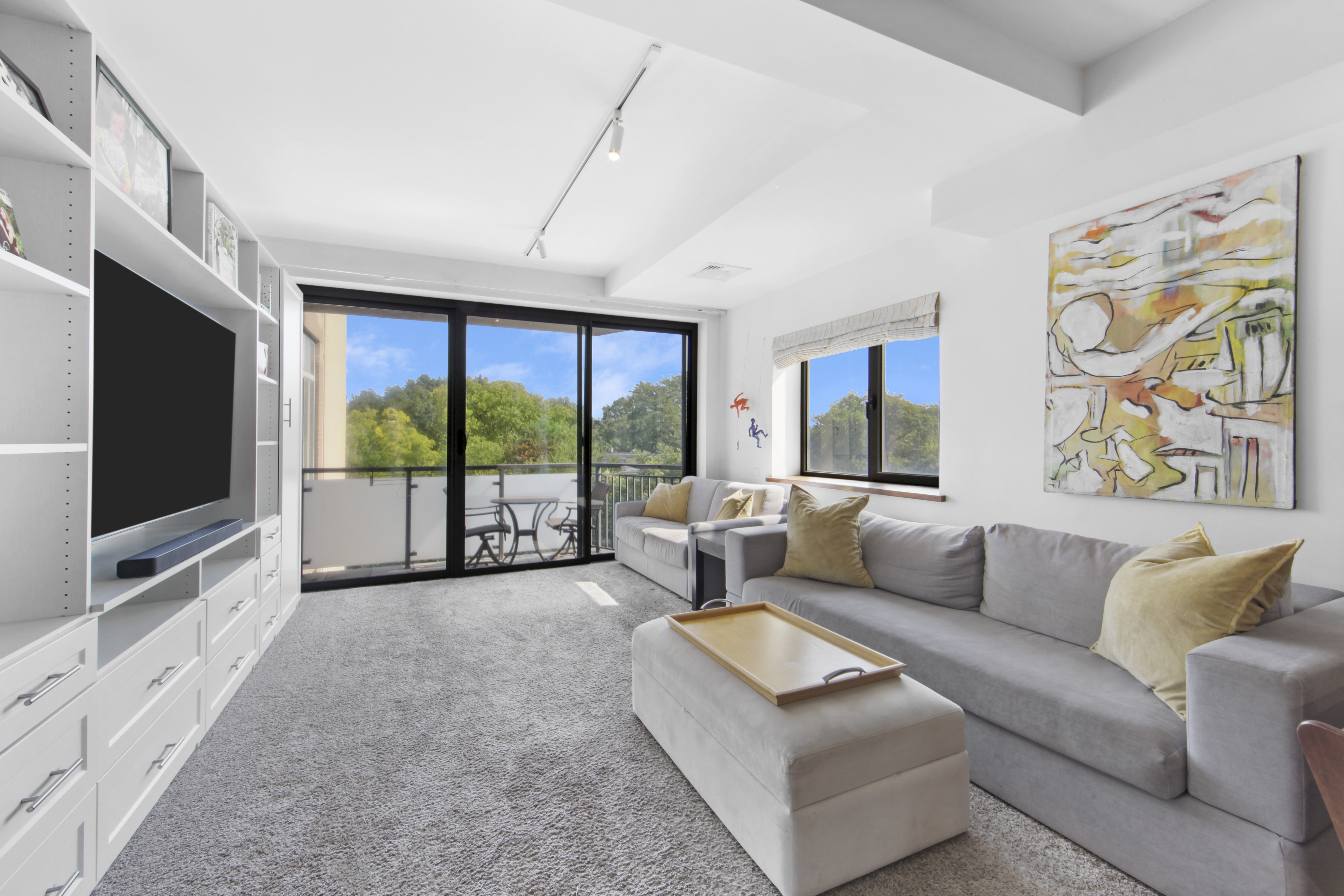 a living room with furniture flat screen tv and a large window