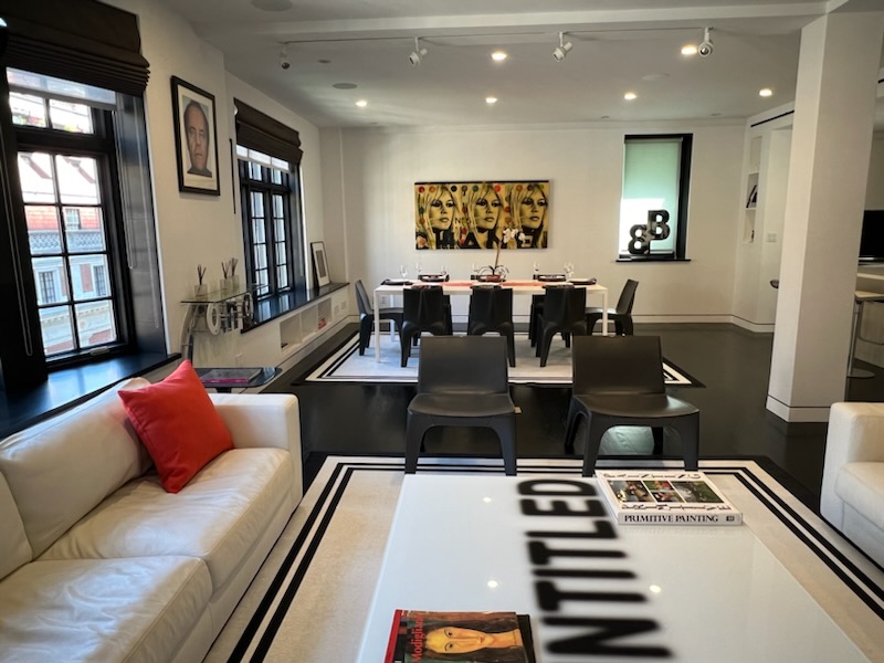 a living room with furniture a table and kitchen view