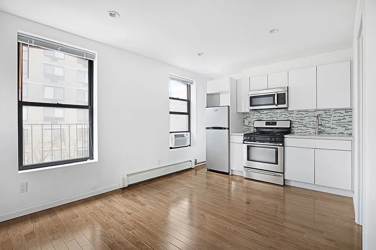 a kitchen with granite countertop white cabinets and stainless steel appliances