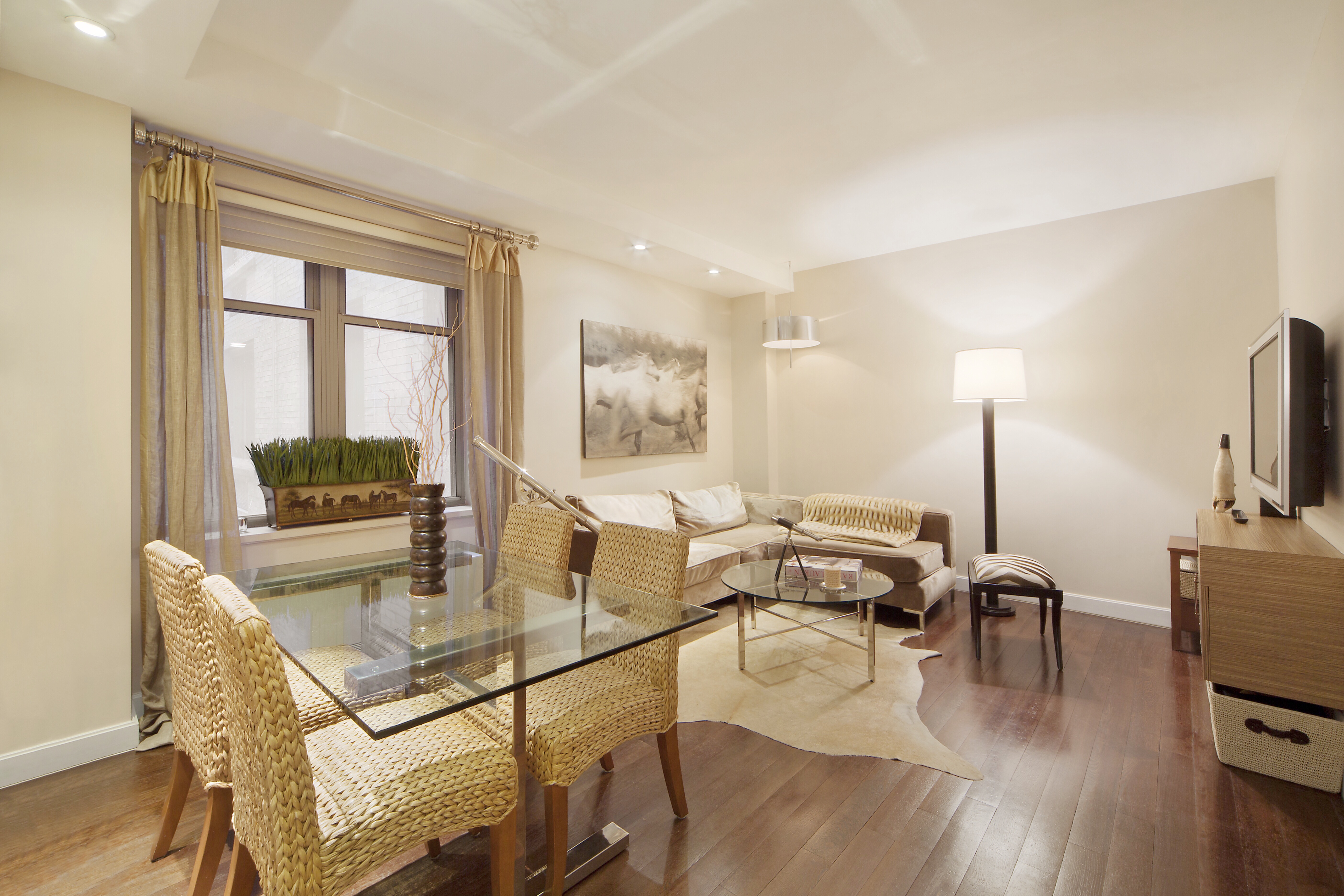 a living room with furniture a flat screen tv and a table