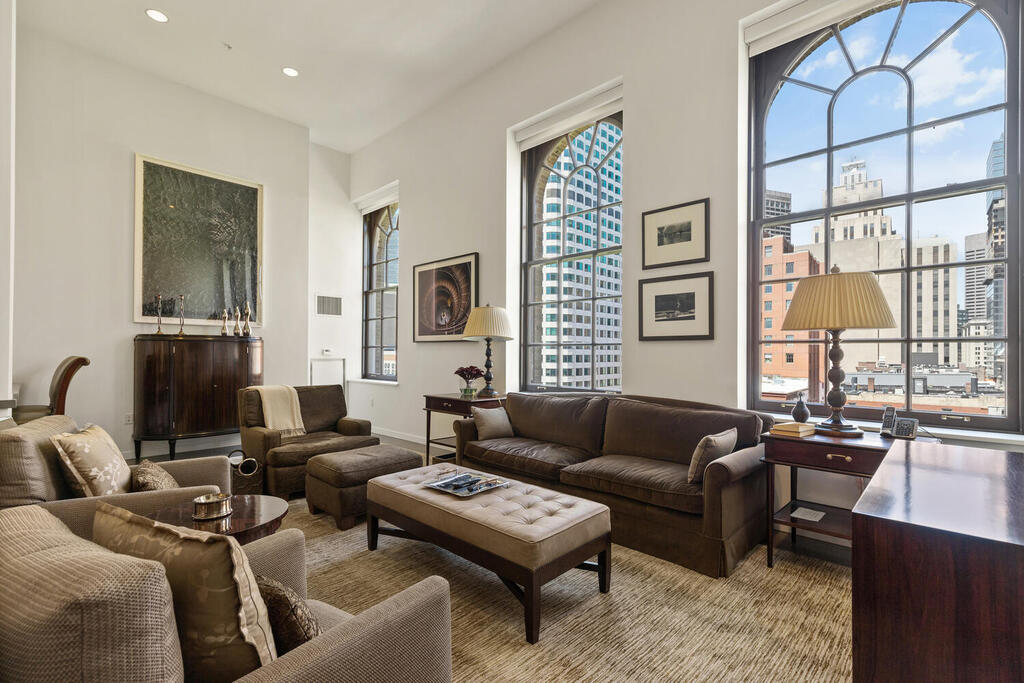 a living room with furniture a large window and a flat screen tv