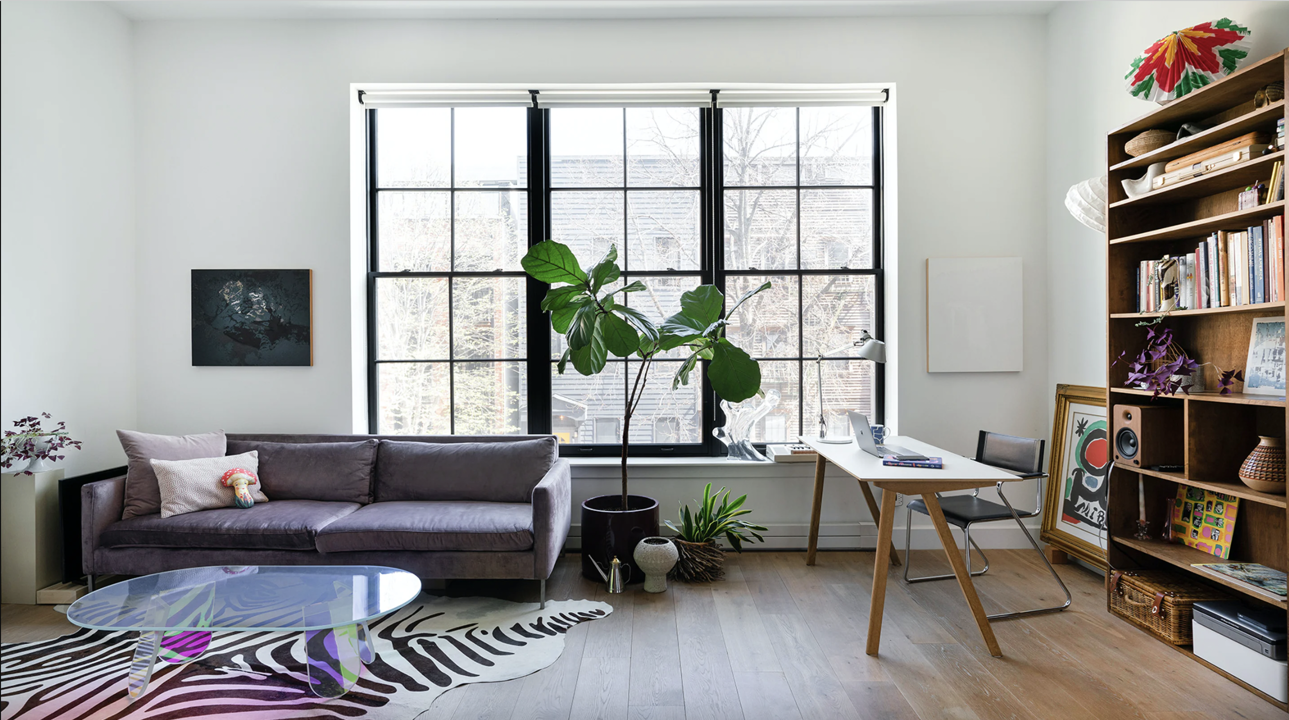 a living room with furniture a bookshelf and a large window