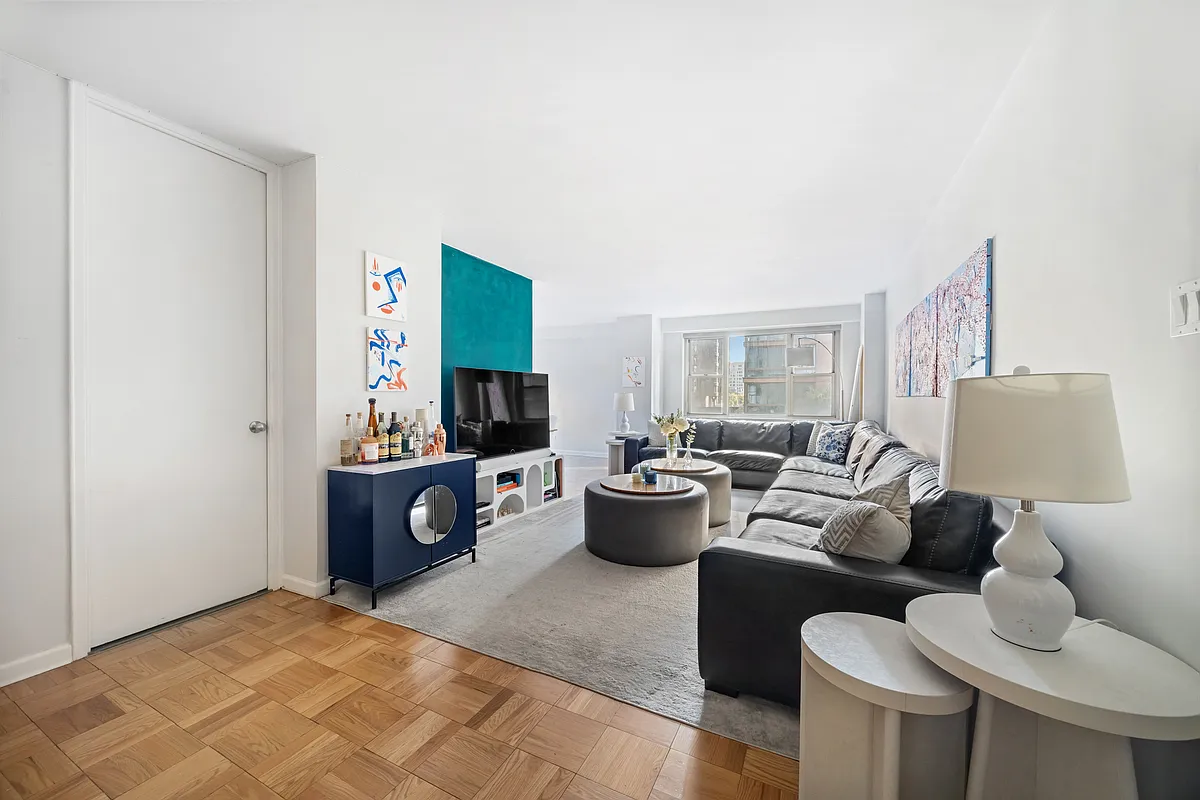 a living room with furniture a flat screen tv and a window