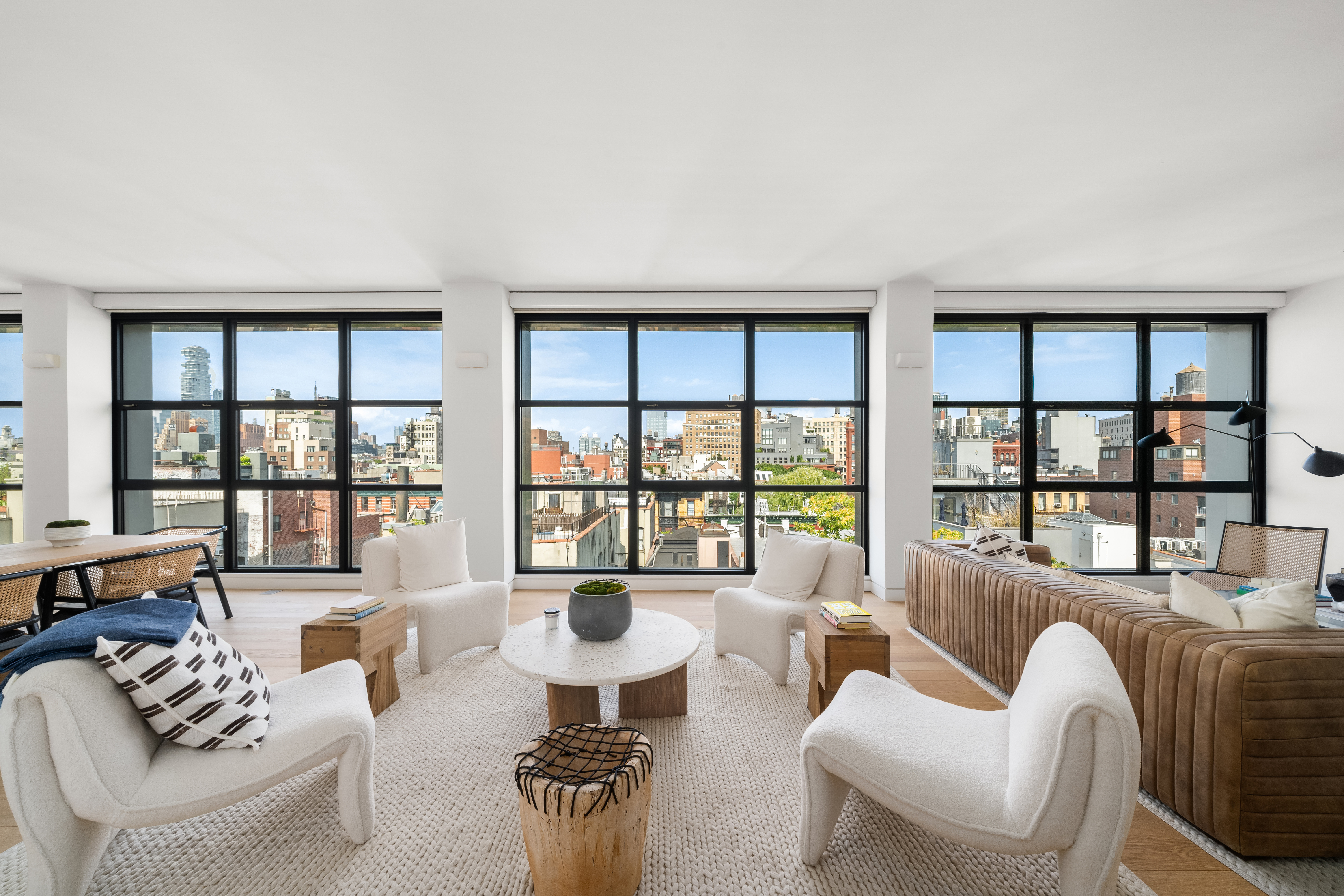 a living room with furniture a table and large windows