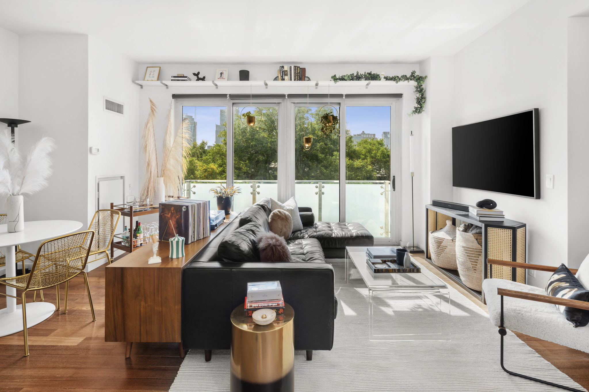 a living room with furniture a flat screen tv and floor to ceiling window