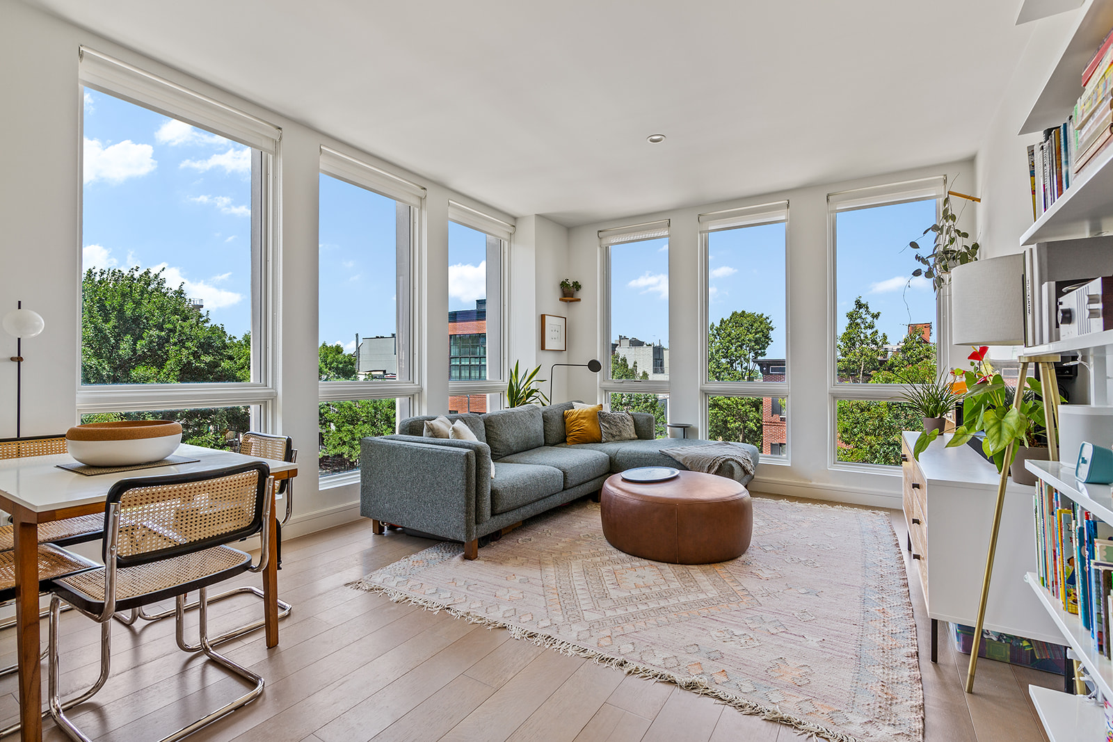 a living room with furniture potted plant and a large window