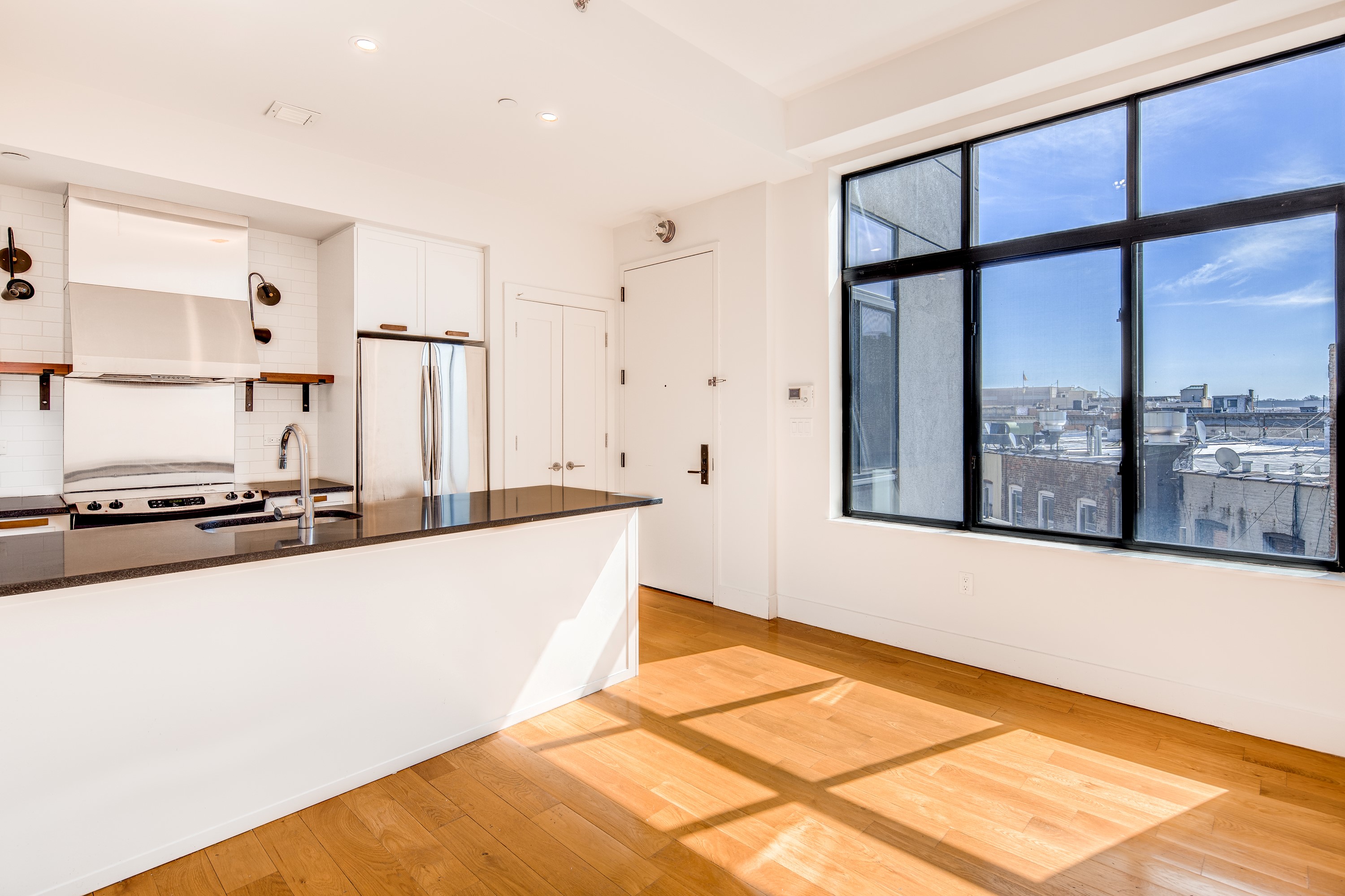 a large kitchen with stainless steel appliances a large window and a counter space