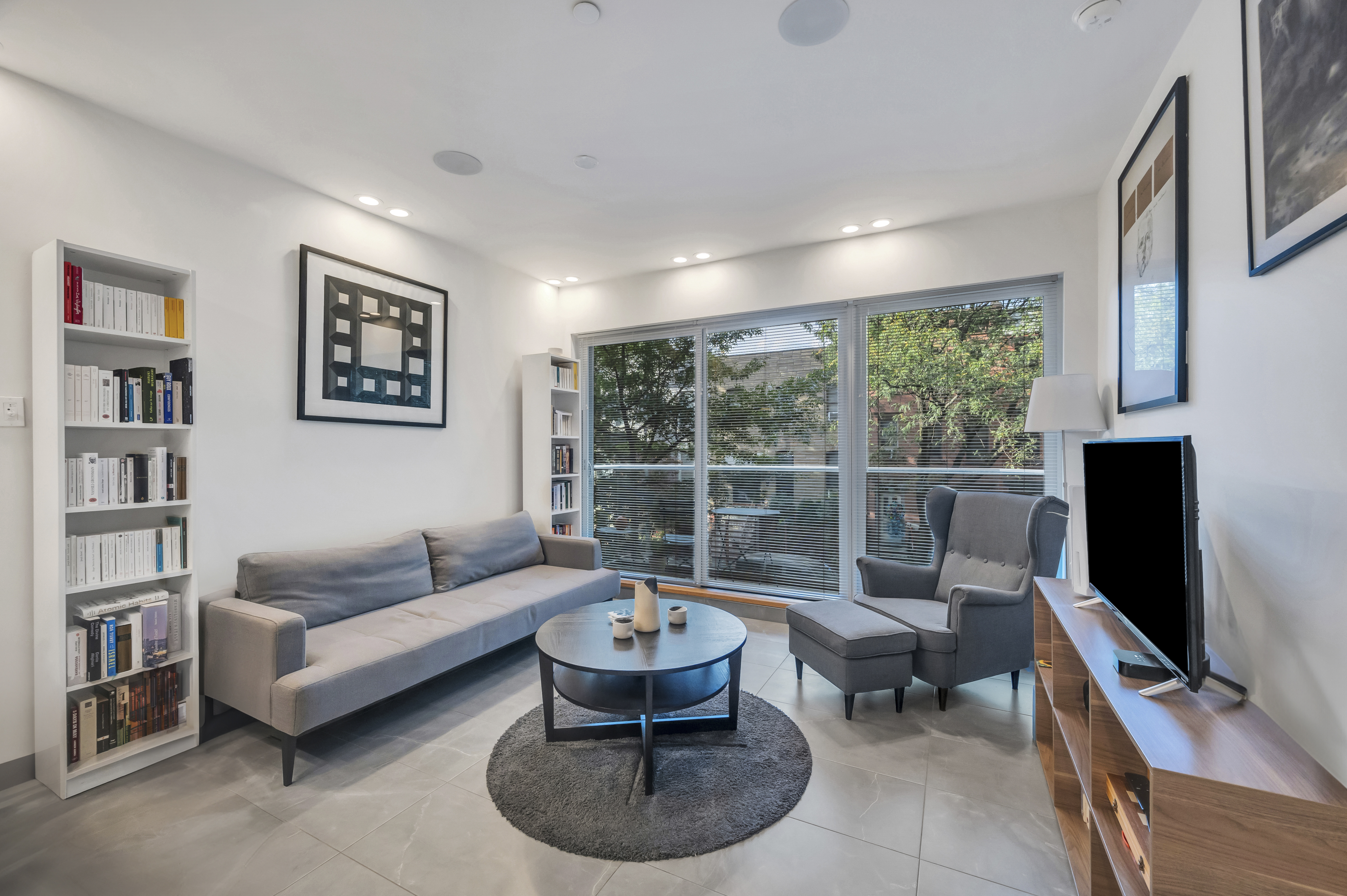 a living room with furniture a rug and a flat screen tv