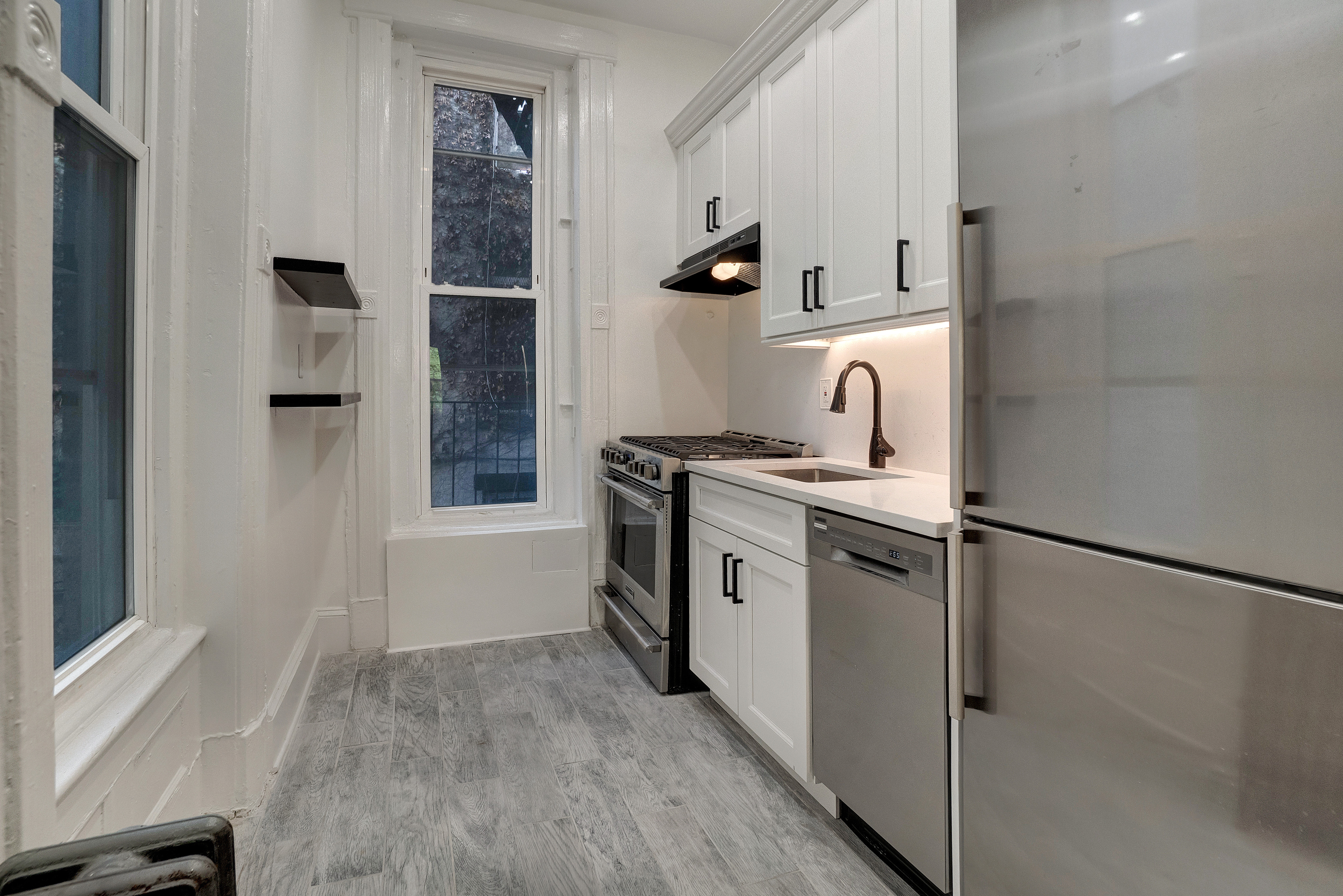 a kitchen with stainless steel appliances granite countertop a refrigerator and a stove