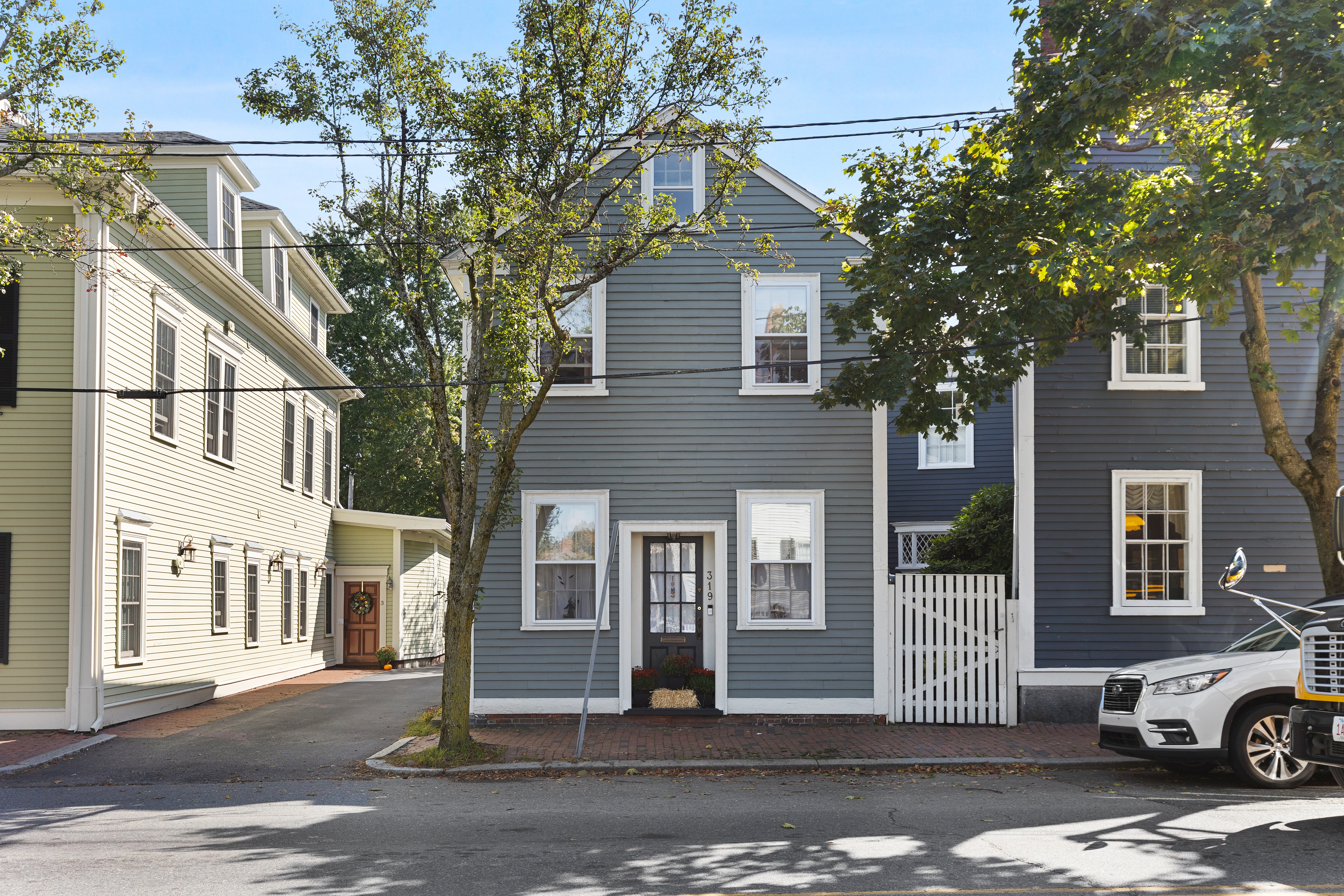 a front view of a house with a tree