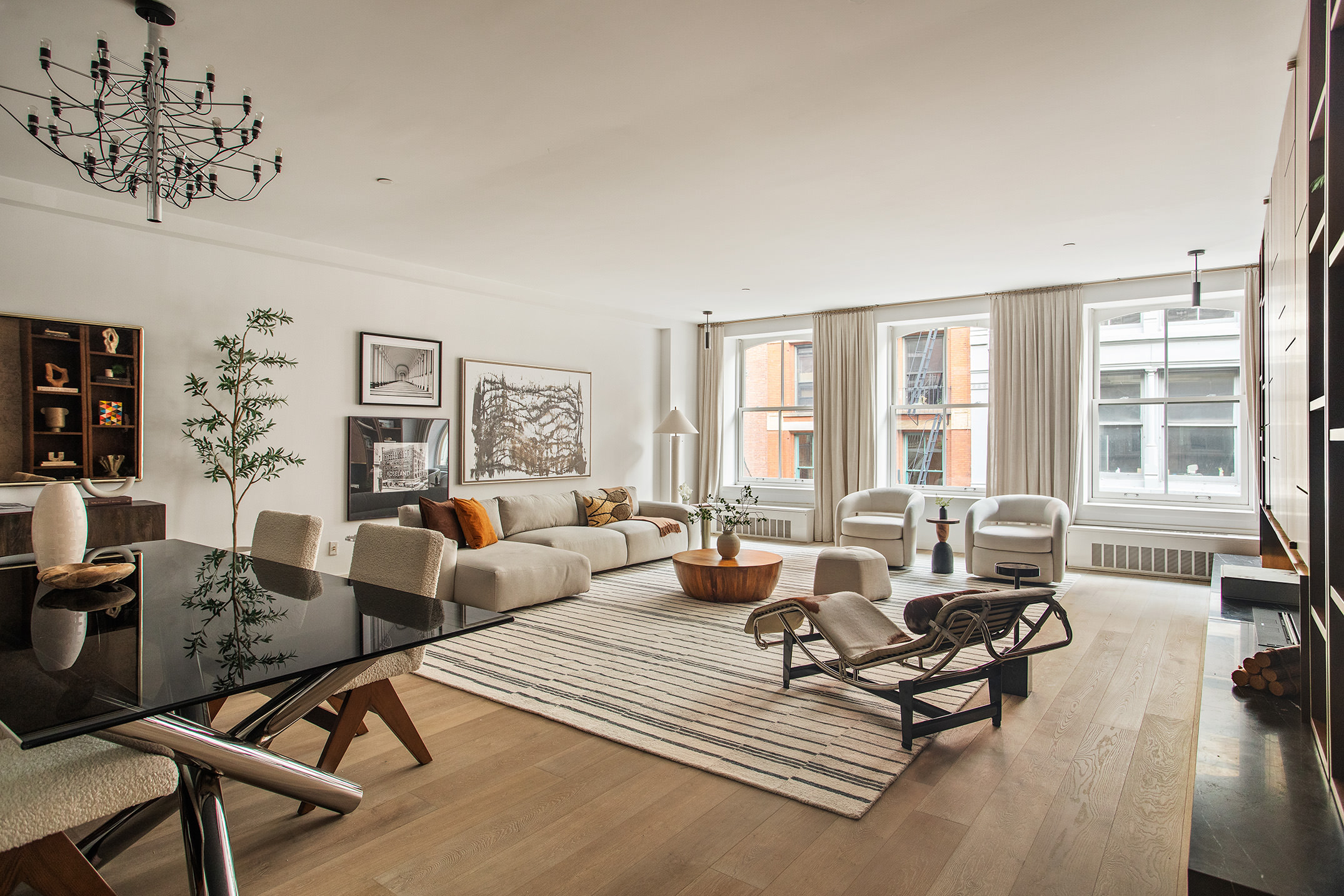 a living room with furniture large window and wooden floor