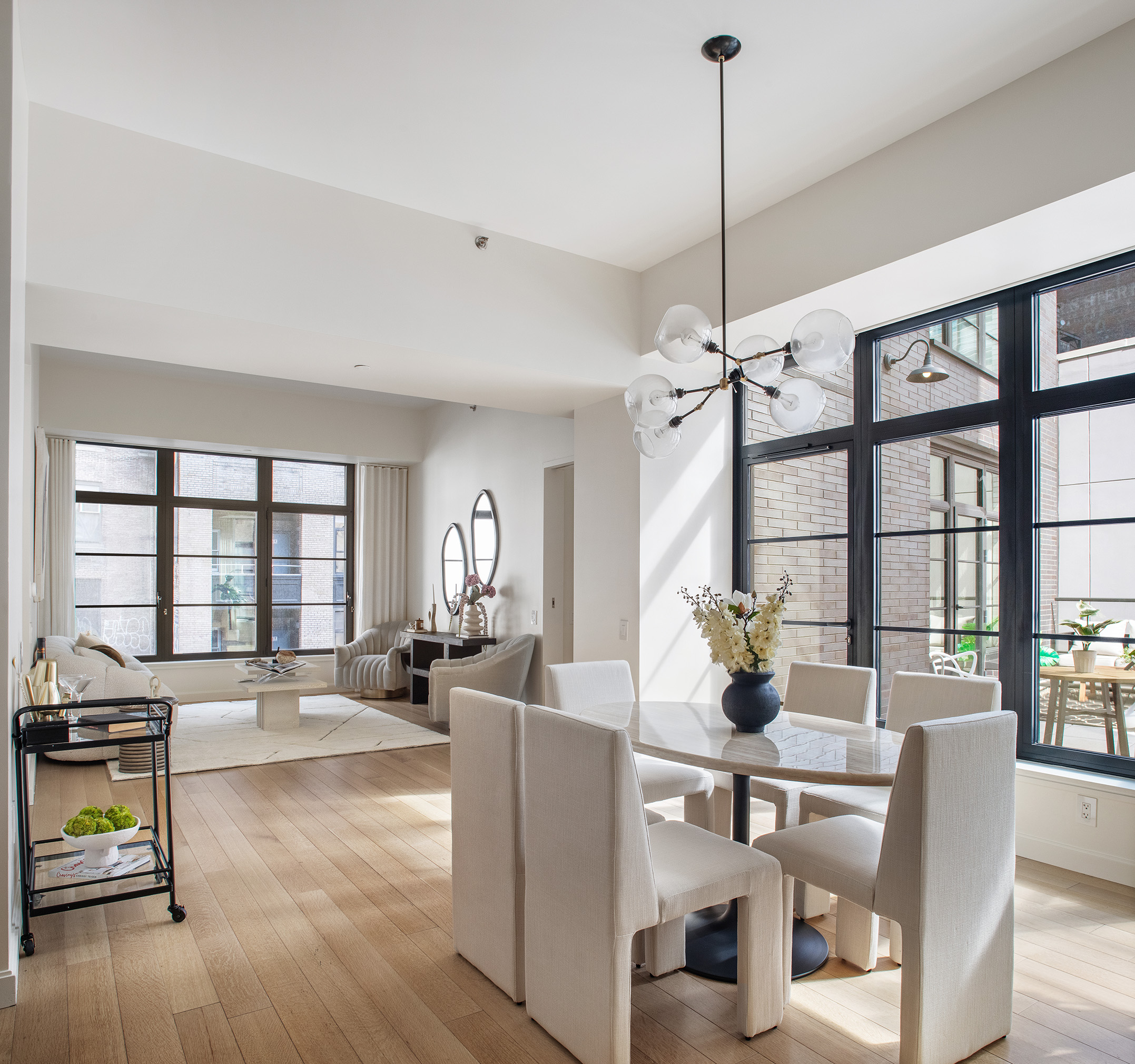 a living room with furniture large window and wooden floor