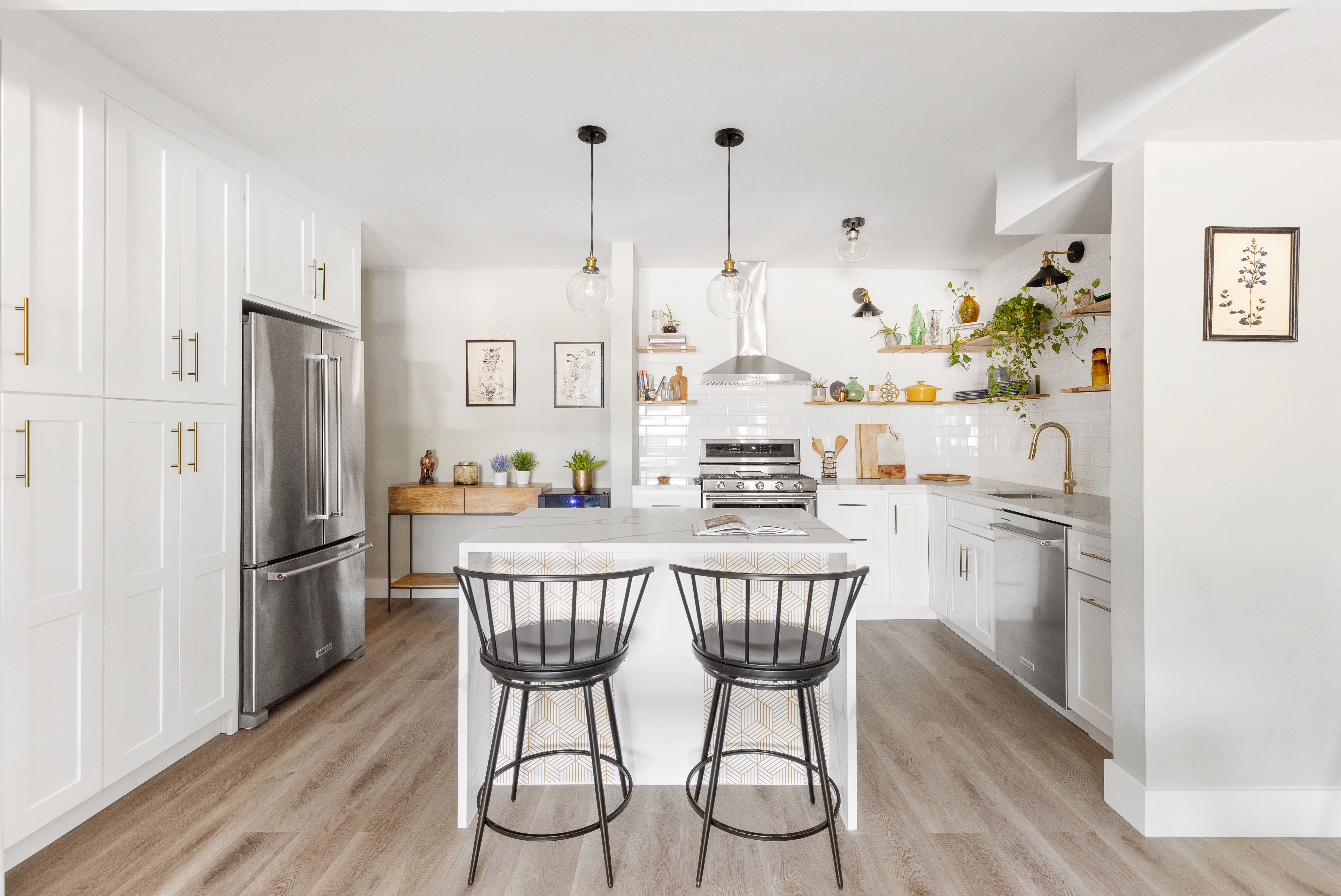 a kitchen with stainless steel appliances a white table chairs and a refrigerator