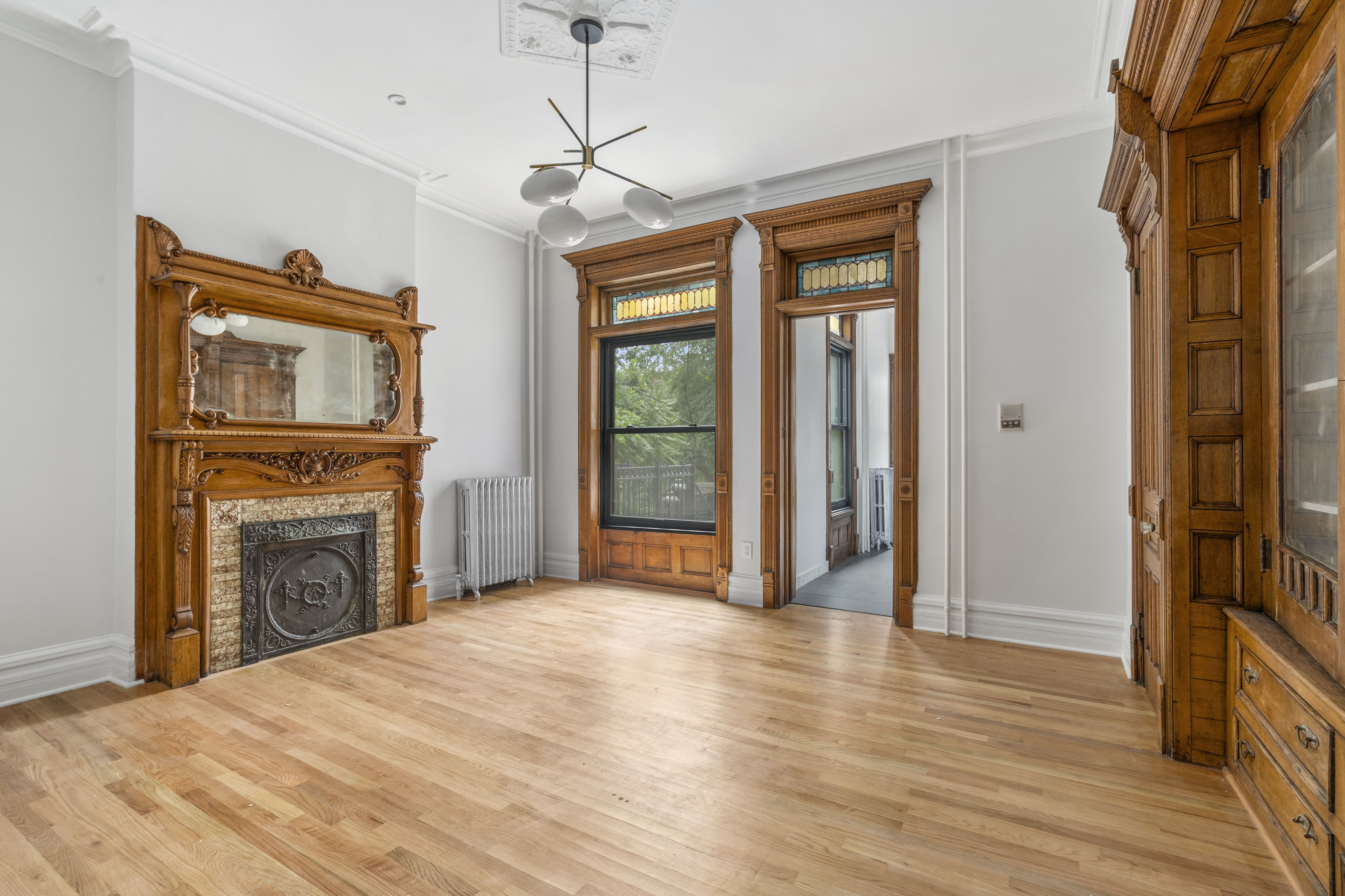 a view of a livingroom with a fireplace wooden floor and a ceiling fan