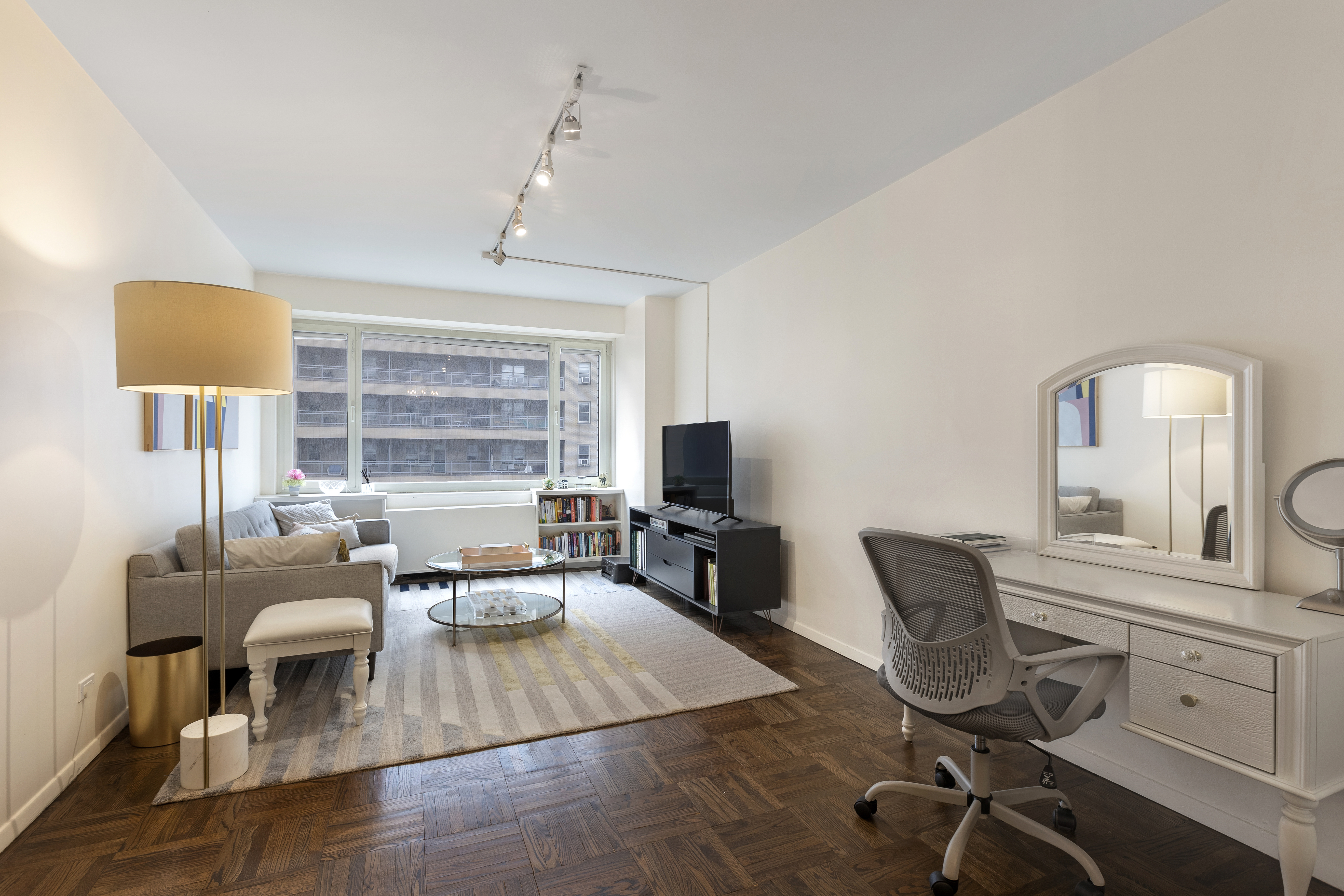 a view of a workspace with furniture and a window