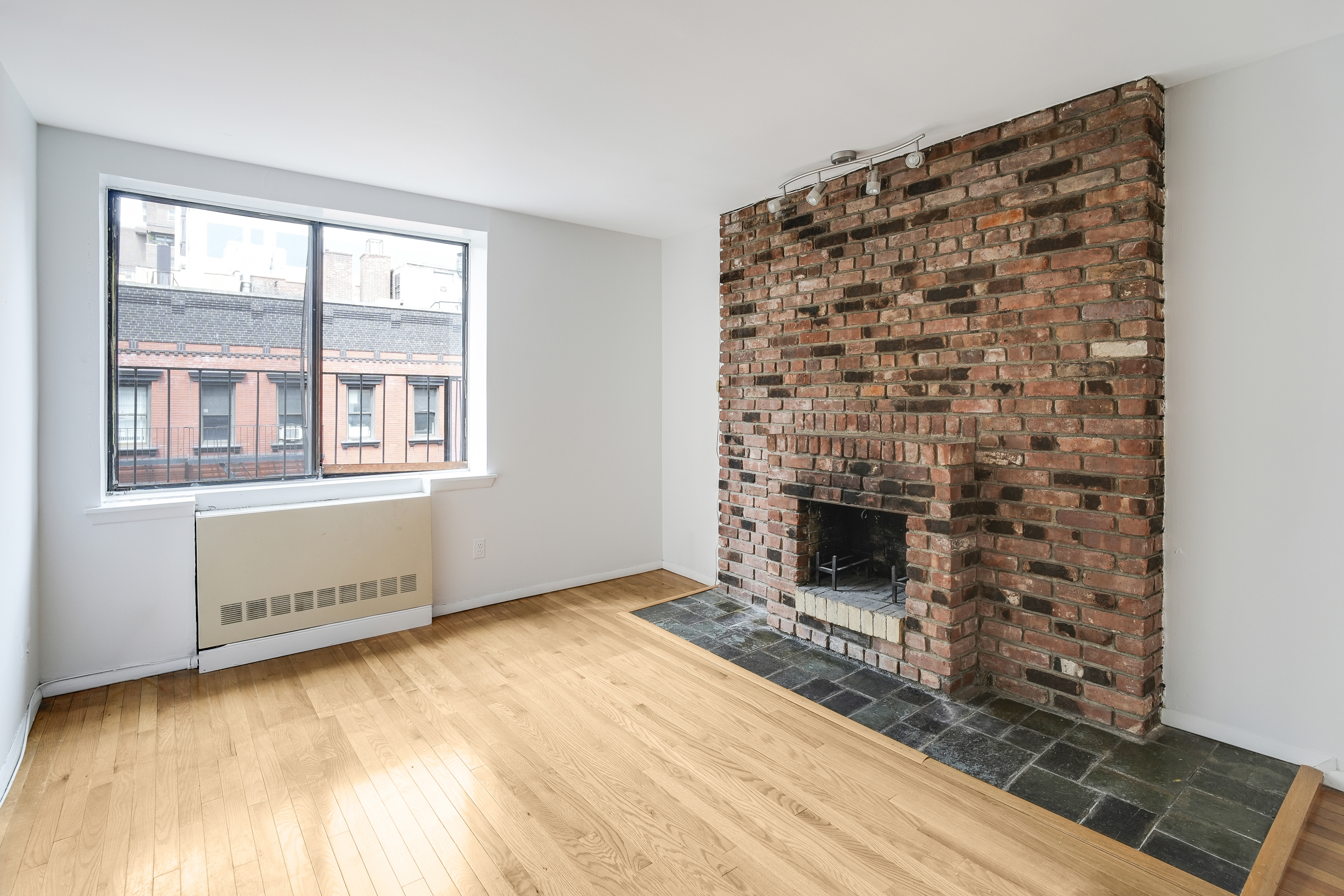 wooden floor fireplace and windows in an empty room