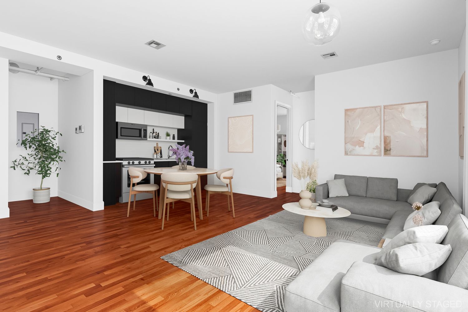 a living room with furniture potted plant and kitchen view