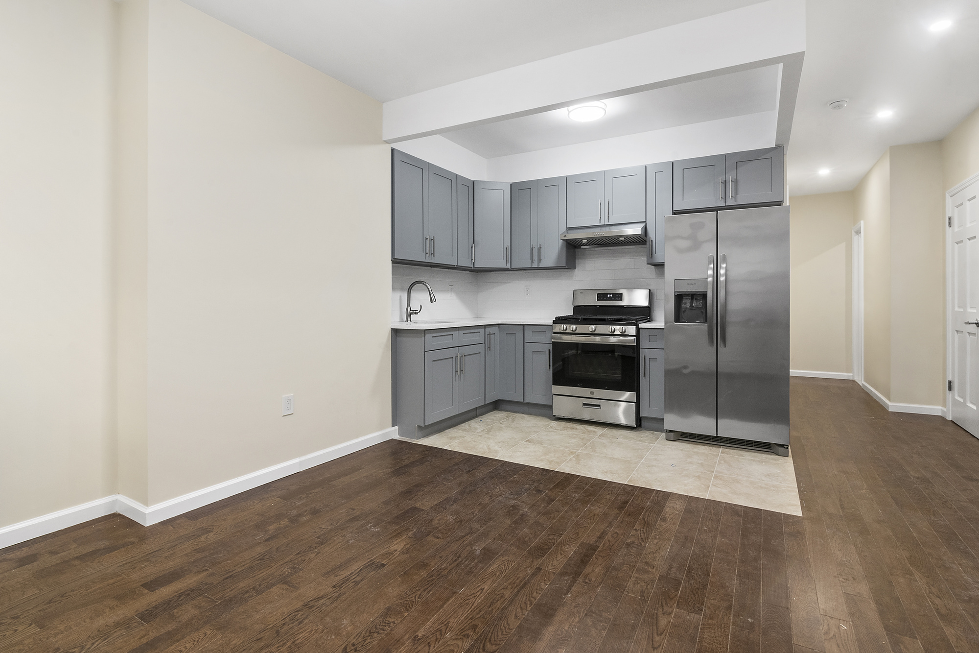 a kitchen with granite countertop a stove a refrigerator and a sink